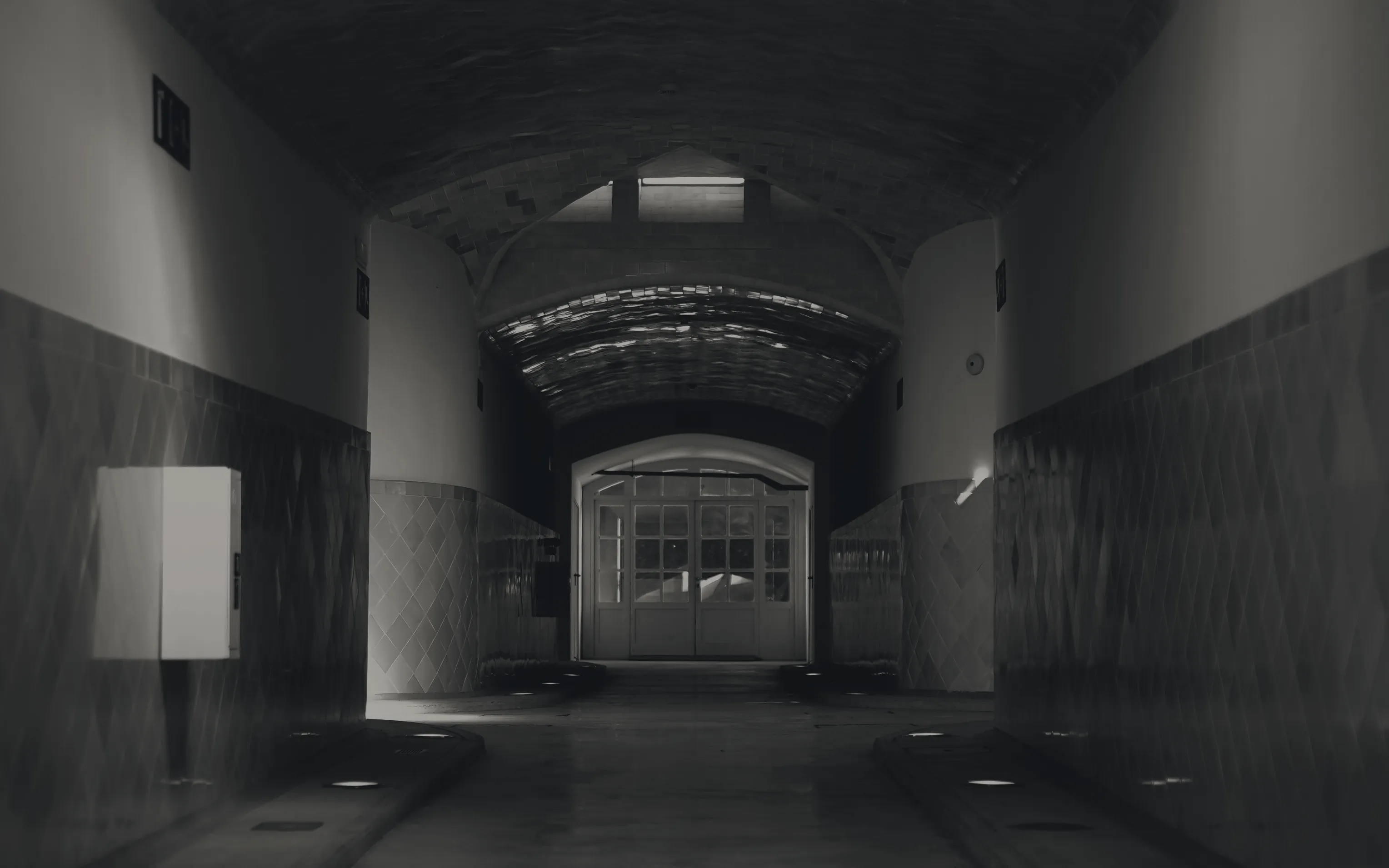 A long institutional corridor, lit at the far end