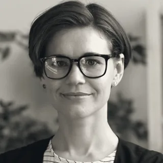 Nadia Fournier, principal for financial services, in glasses, with plants behind her