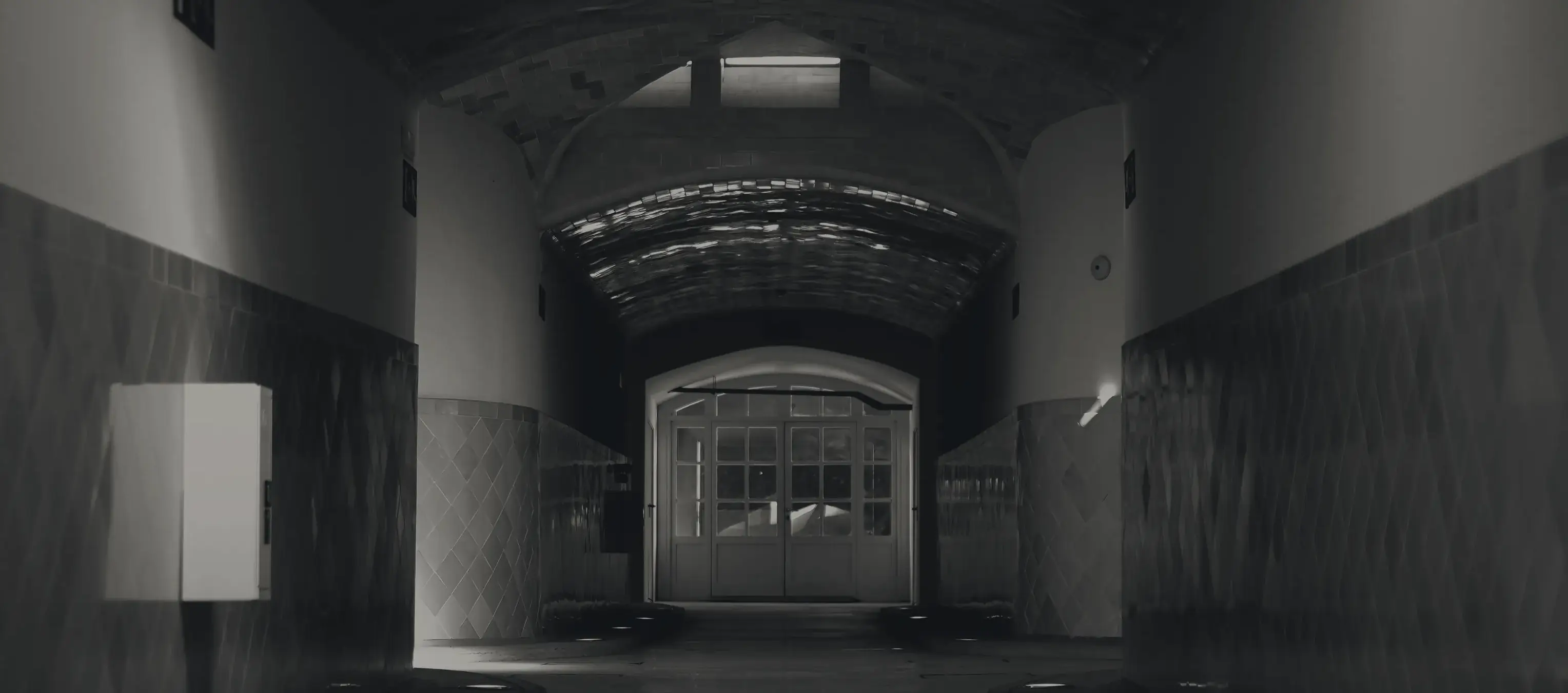 A long institutional corridor, lit at the far end