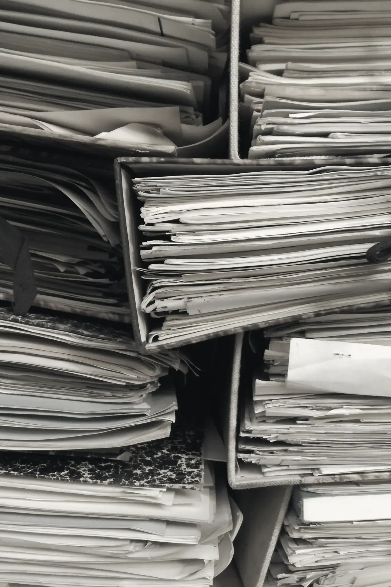 Bundles of papers tied shut with cloth ties, stacked on shelves