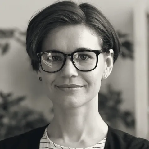 Nadia Fournier, principal for financial services, in glasses, with plants behind her