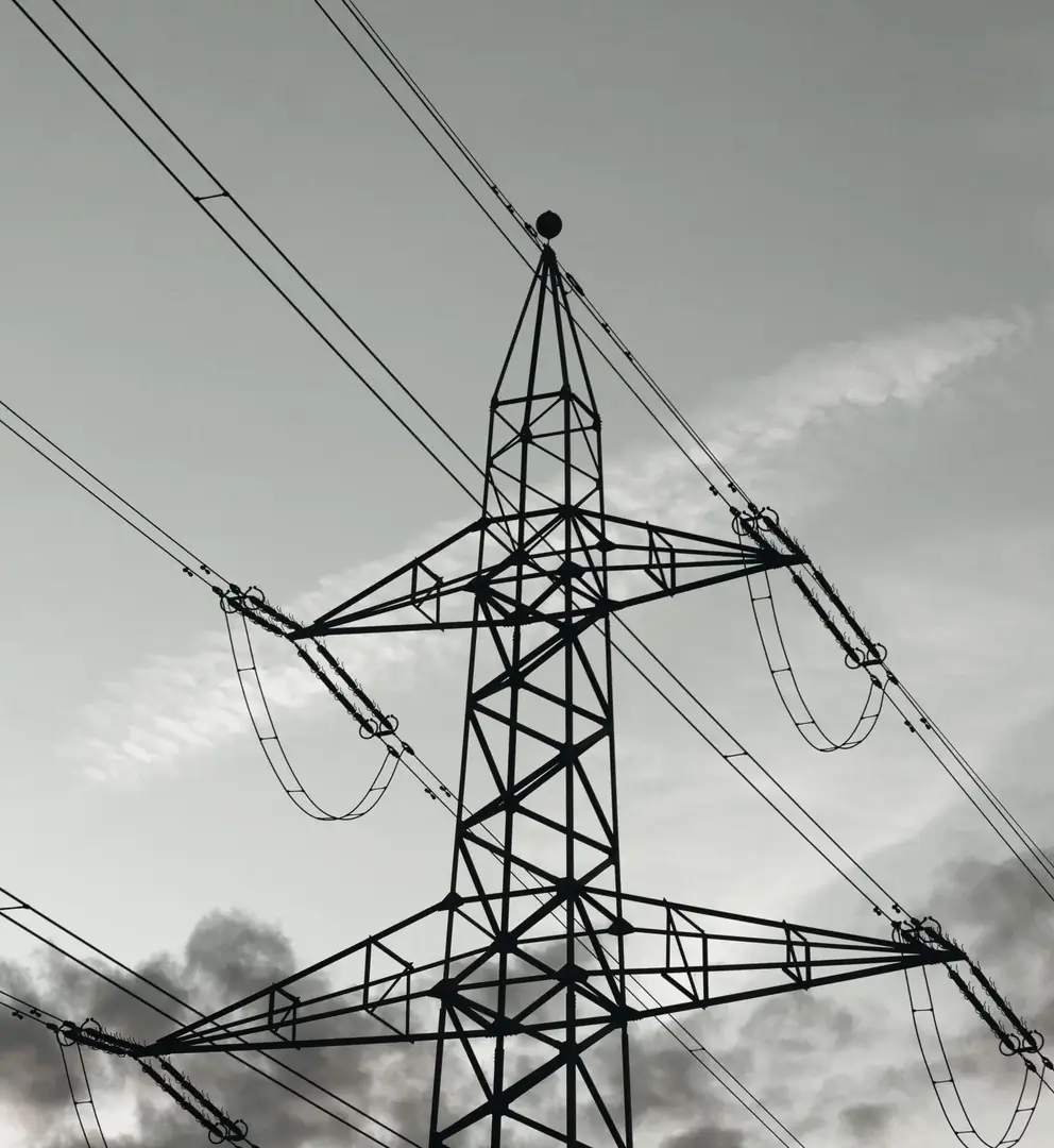 A switchyard at a substation, gantries and insulators against a flat sky
