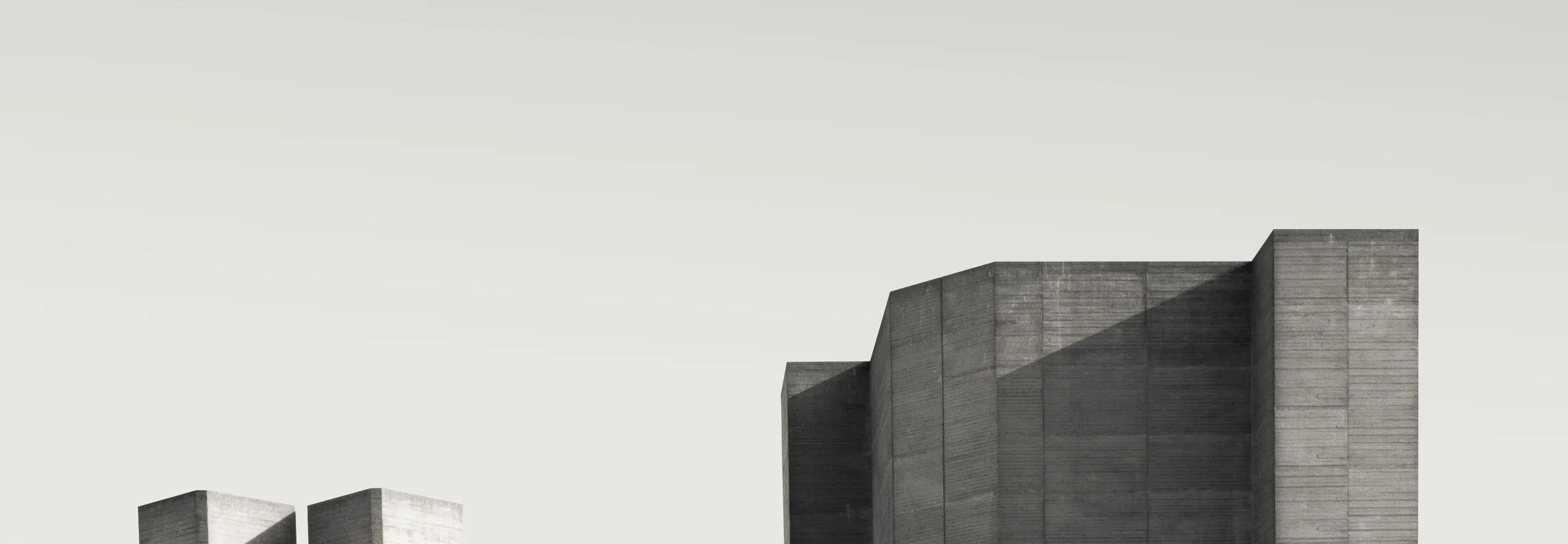 A concrete institutional building, stepped blocks against a pale sky