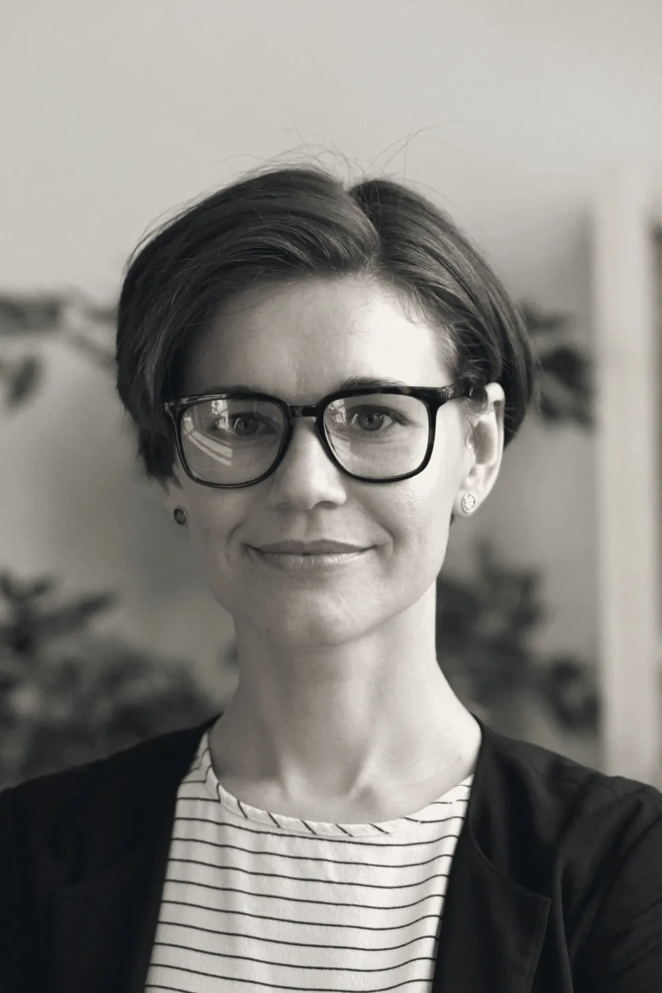 Nadia Fournier, principal for financial services, in glasses, with plants behind her