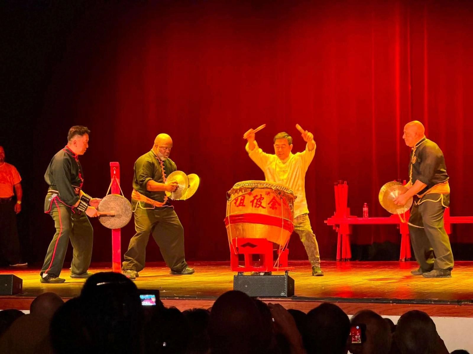 Syracuse Kung Fu members performing with drum and cymbals on stage