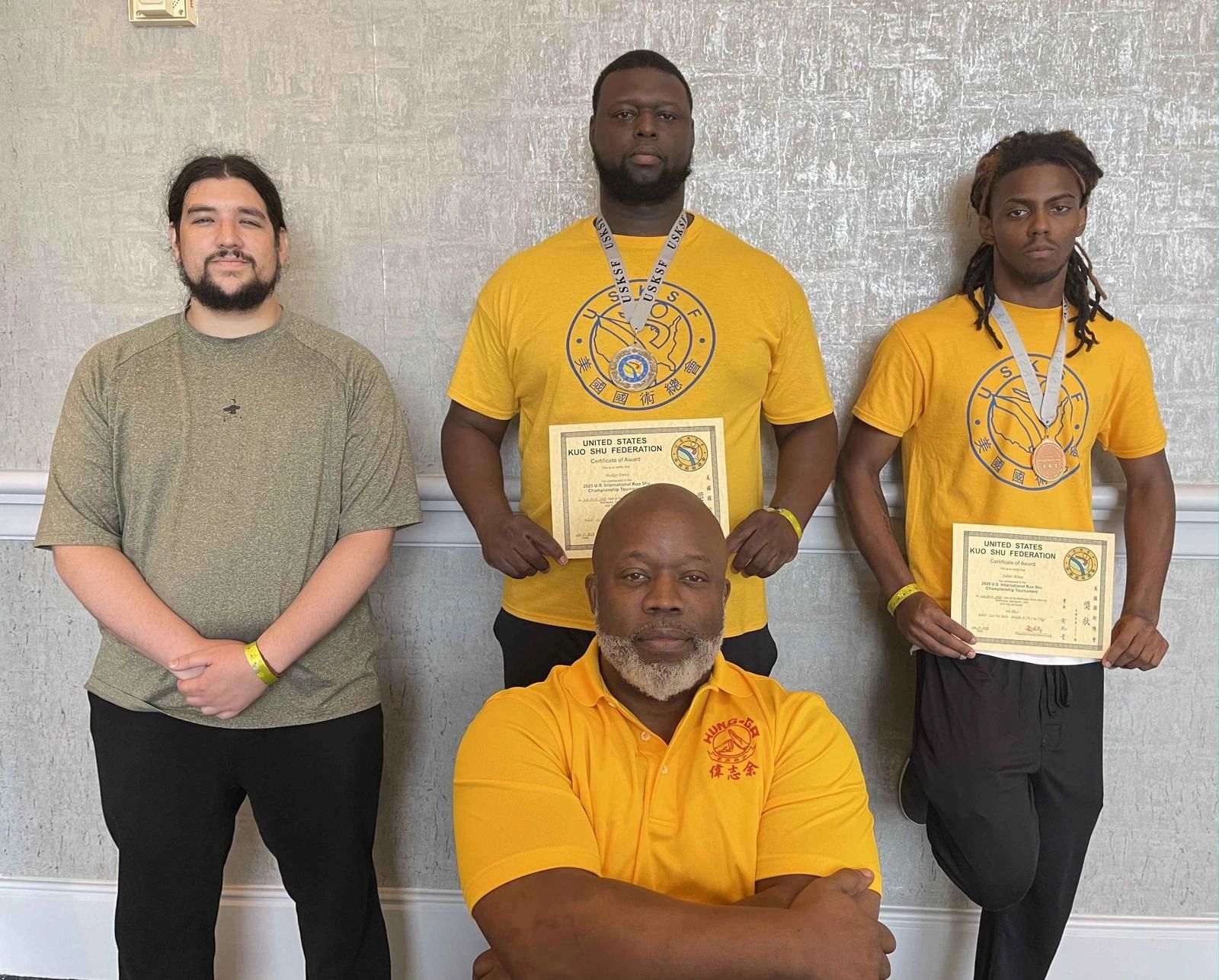 Sifu Bey with three Fight Team members holding United States Kuo Shu Federation medals and certificates