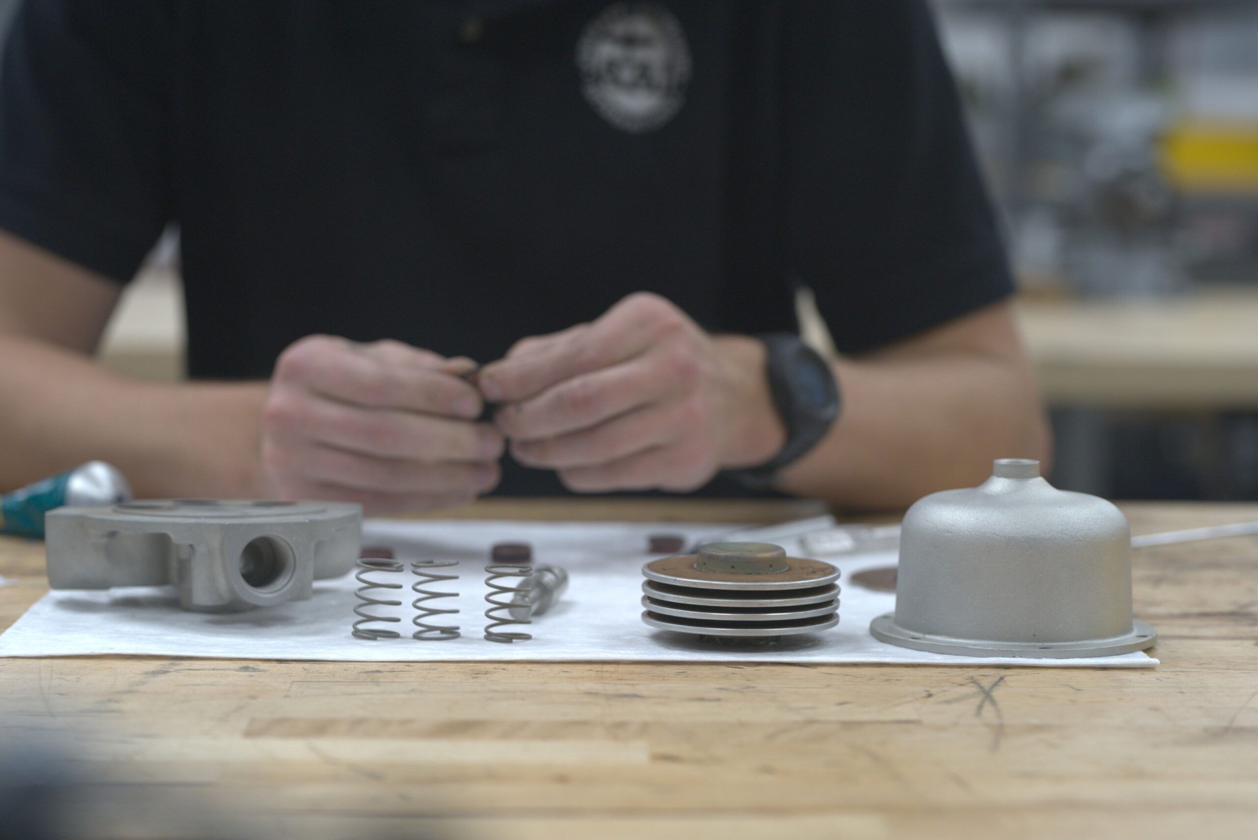 Technician assembling and inspecting aircraft component parts on a workbench, focusing on precision and quality control.