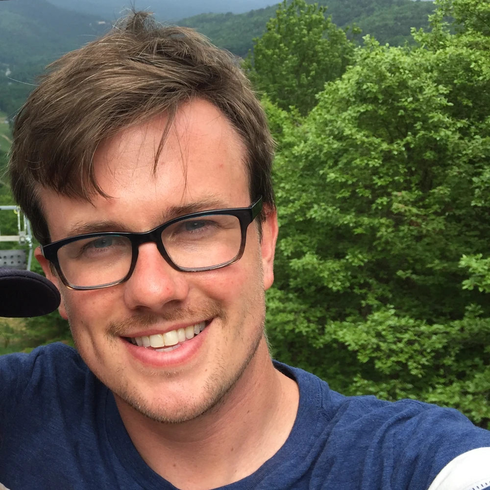 Andy Hamilton outdoors wearing glasses and a blue shirt