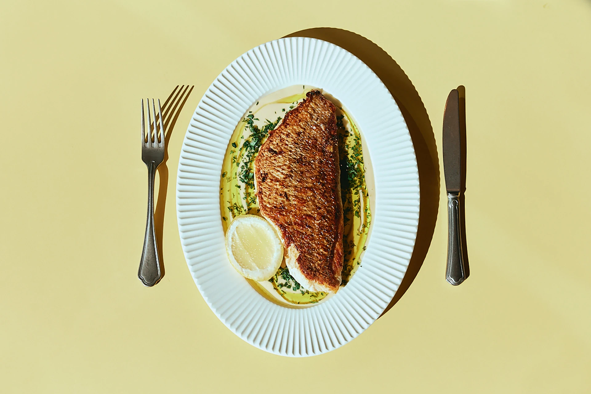 Crisp-skinned fish fillet with herb oil and lemon at The Tropic