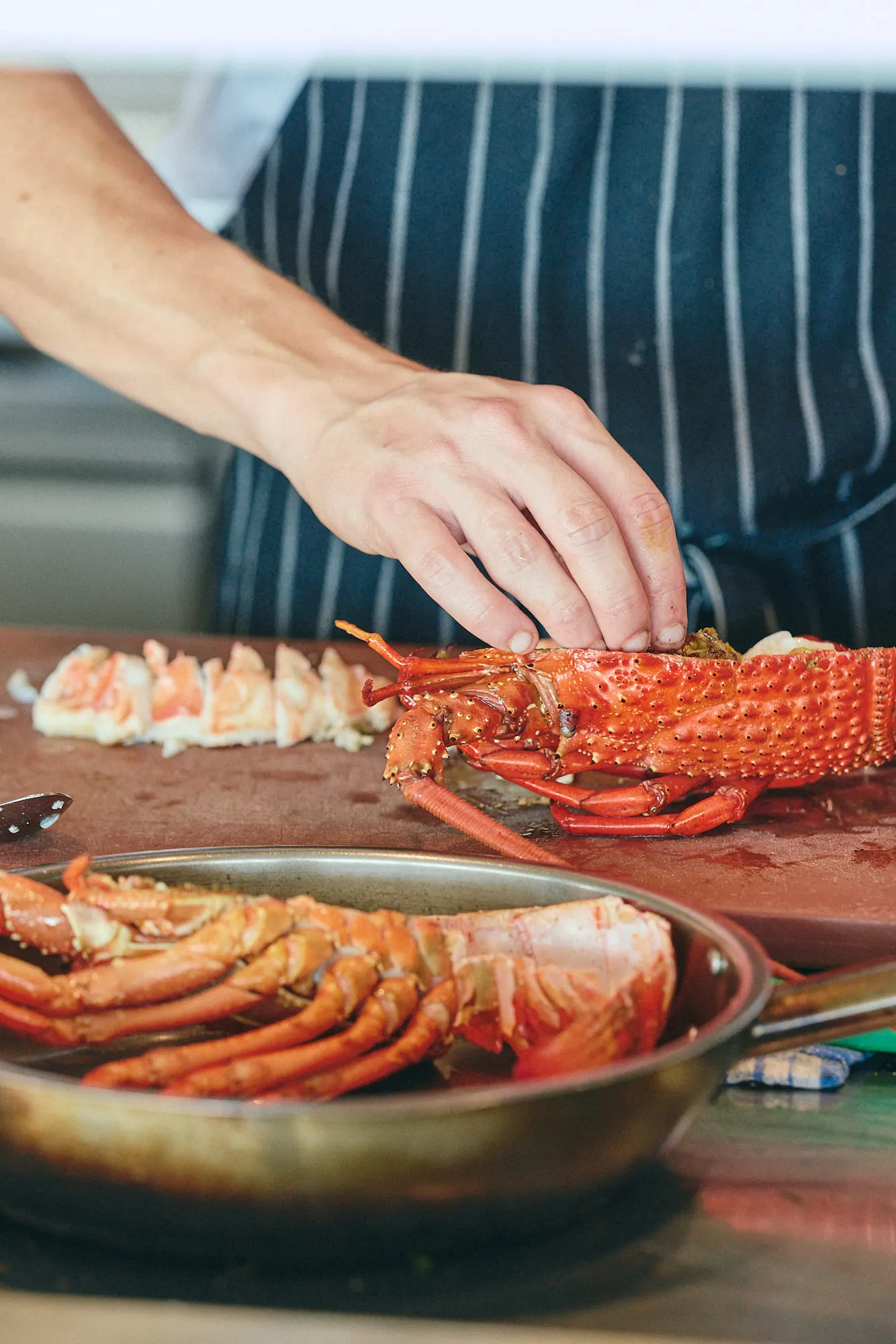 Chef preparing fresh rock lobster in The Tropic kitchen