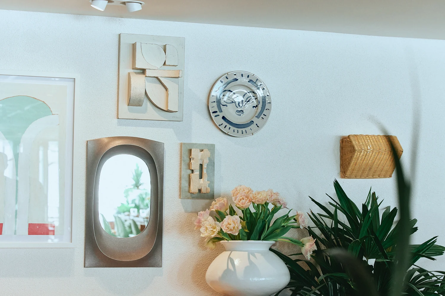 Ceramic wall art, a mirror and fresh flowers inside The Tropic