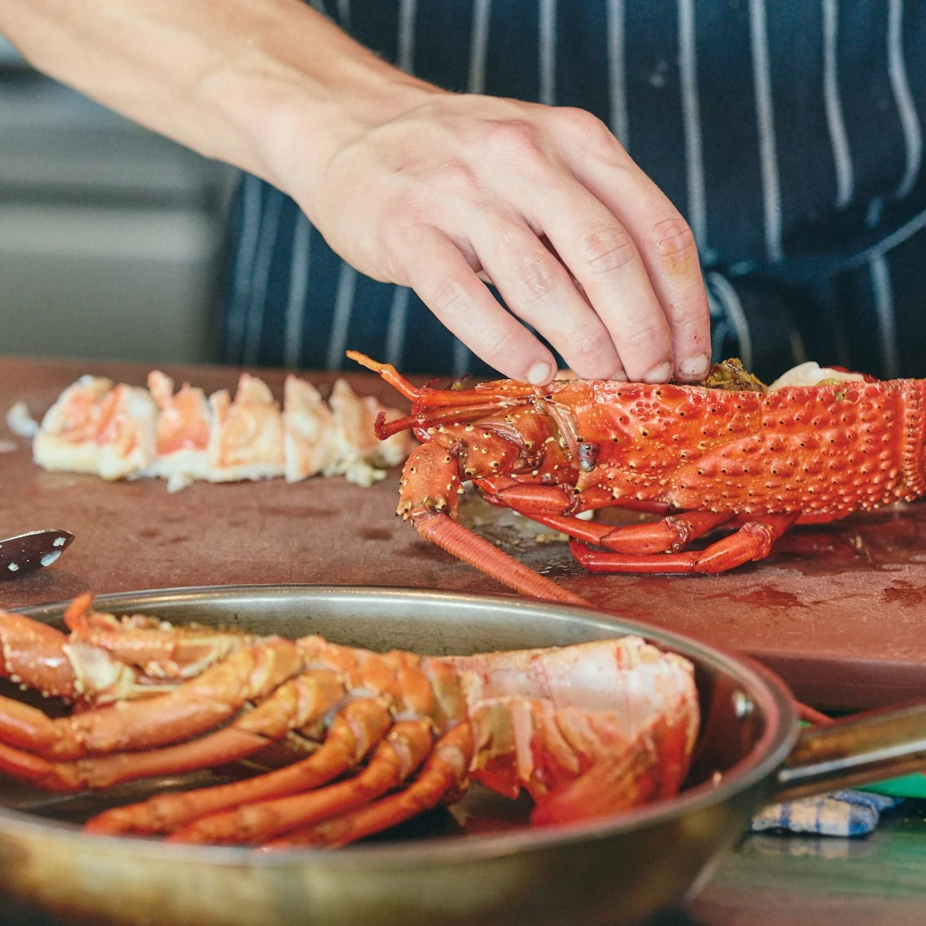 Chef preparing fresh rock lobster in The Tropic kitchen