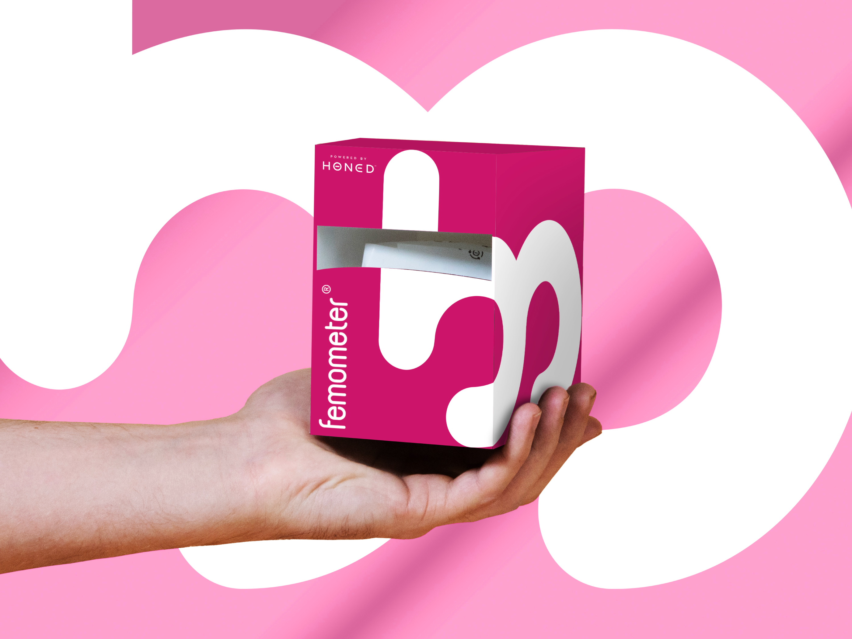 Packaging design mock-up for femometer health product, CPG branding with pink and white graphics held in hand for retail and trade show presentation