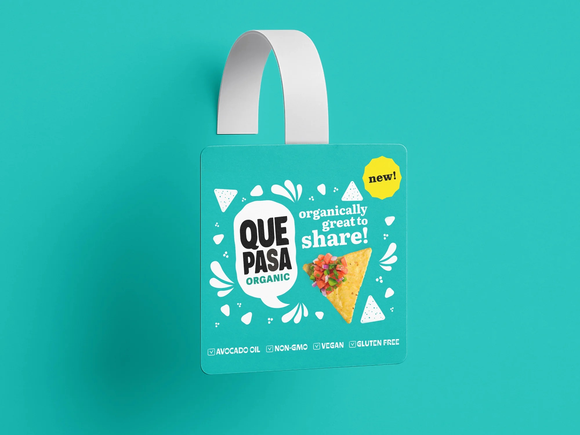 Shelf talker wobbler design for Que Pasa organic tortilla chips, teal hanging tag with Organically Great To Share headline, tortilla chip with salsa photography, New badge, and Avocado Oil Non-GMO Vegan Gluten Free callouts