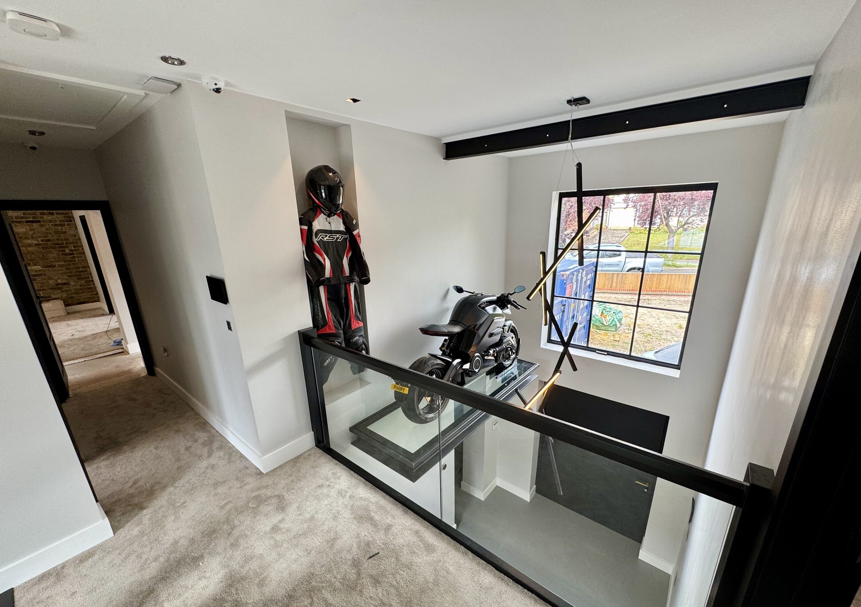 Thornhill full-height entrance with the rare electric motorbike displayed on a glass platform above