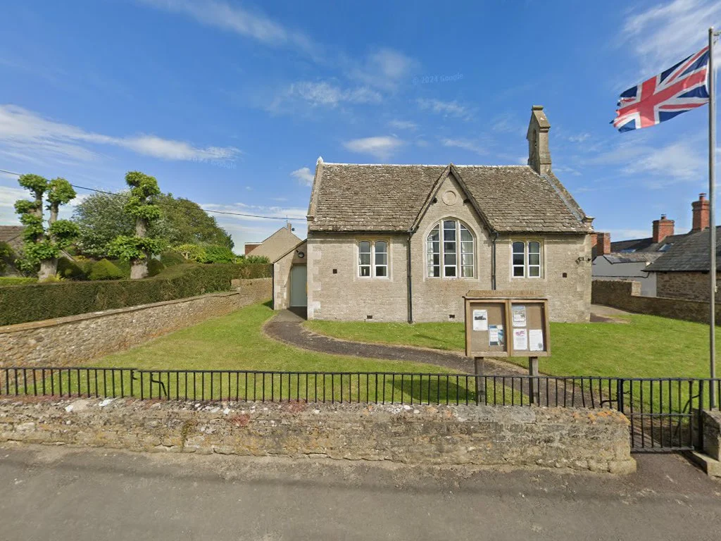 The former village school in Hannington with the village noticeboard and Union flag