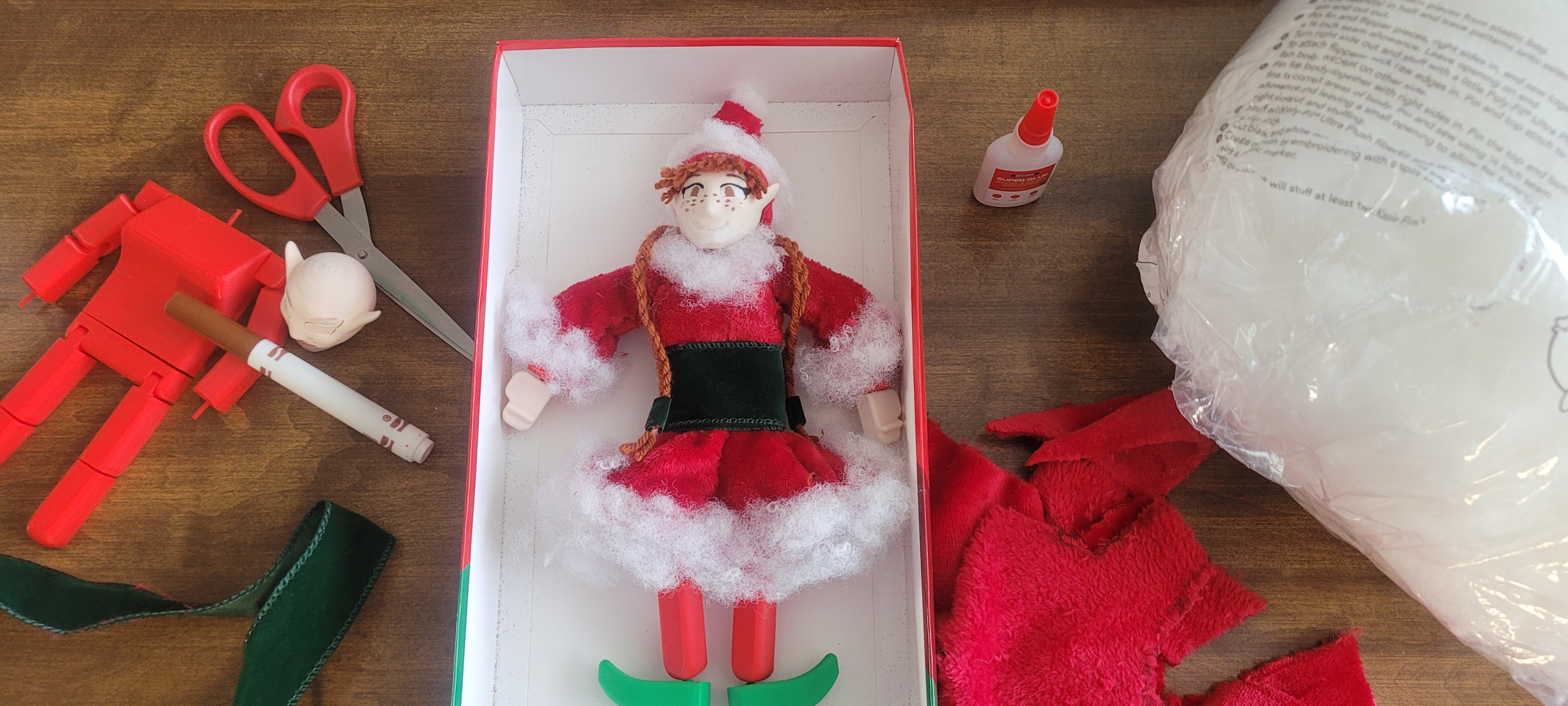Custom 3D-printed elf figure surrounded by craft materials
