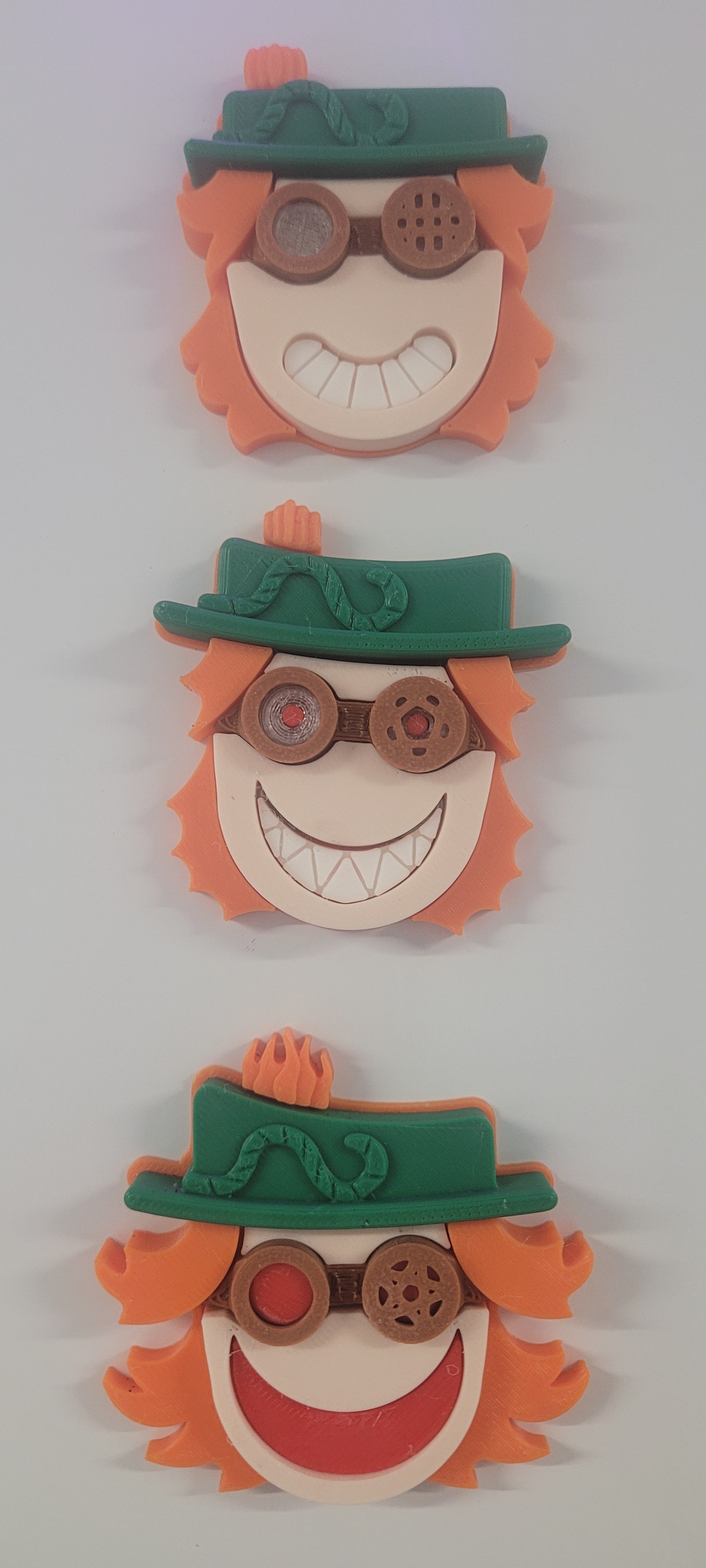Three 3D-printed pumpkin character magnets with goggles and green hats