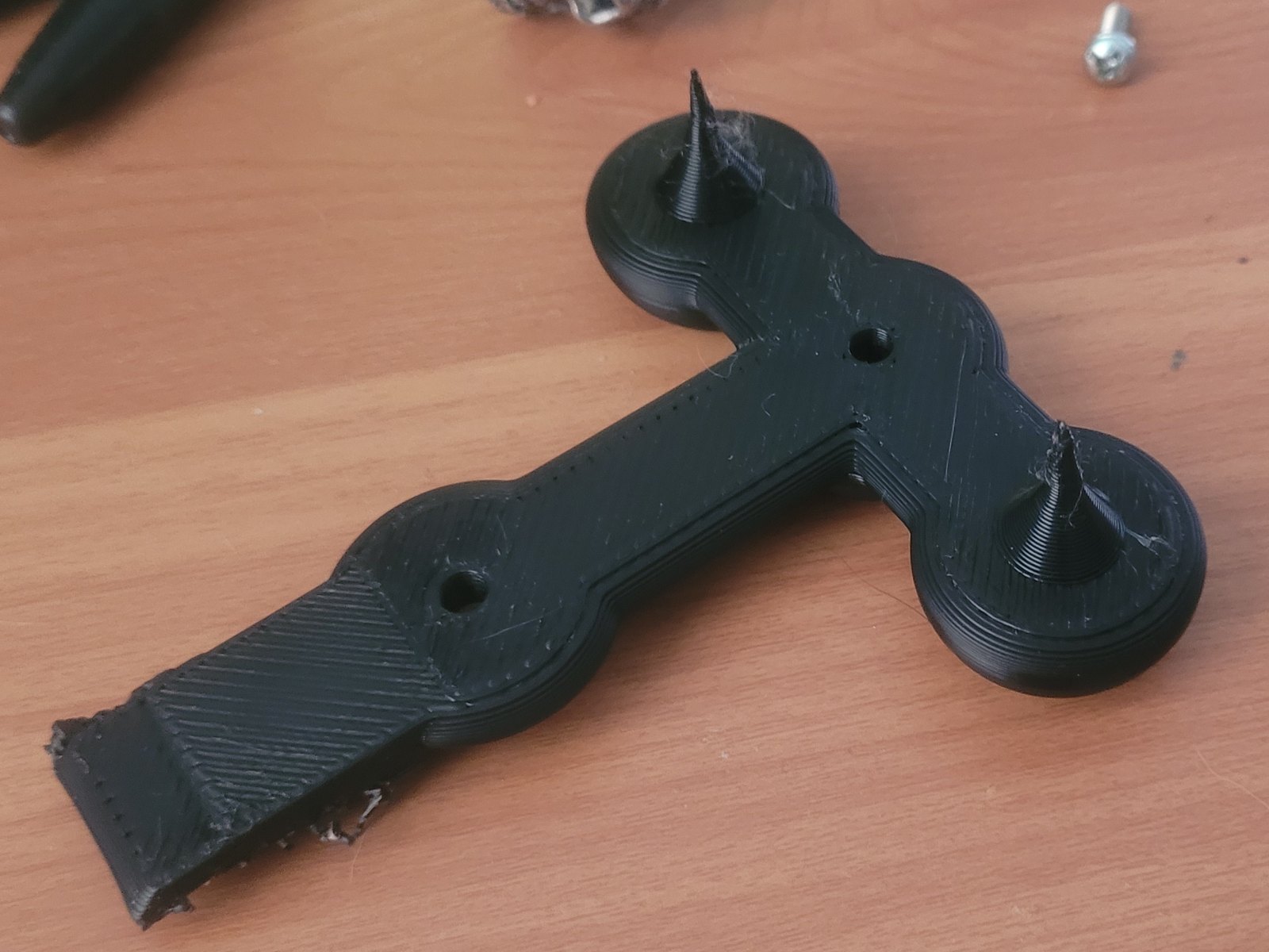Black 3D-printed functional prototype on a workbench