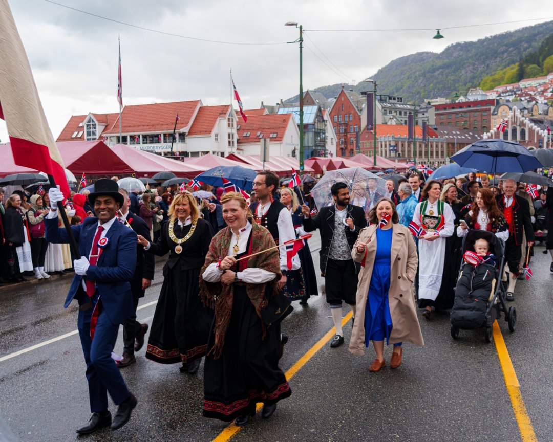 Deltakere med bunad og norske flagg i prosesjonen – A7400170