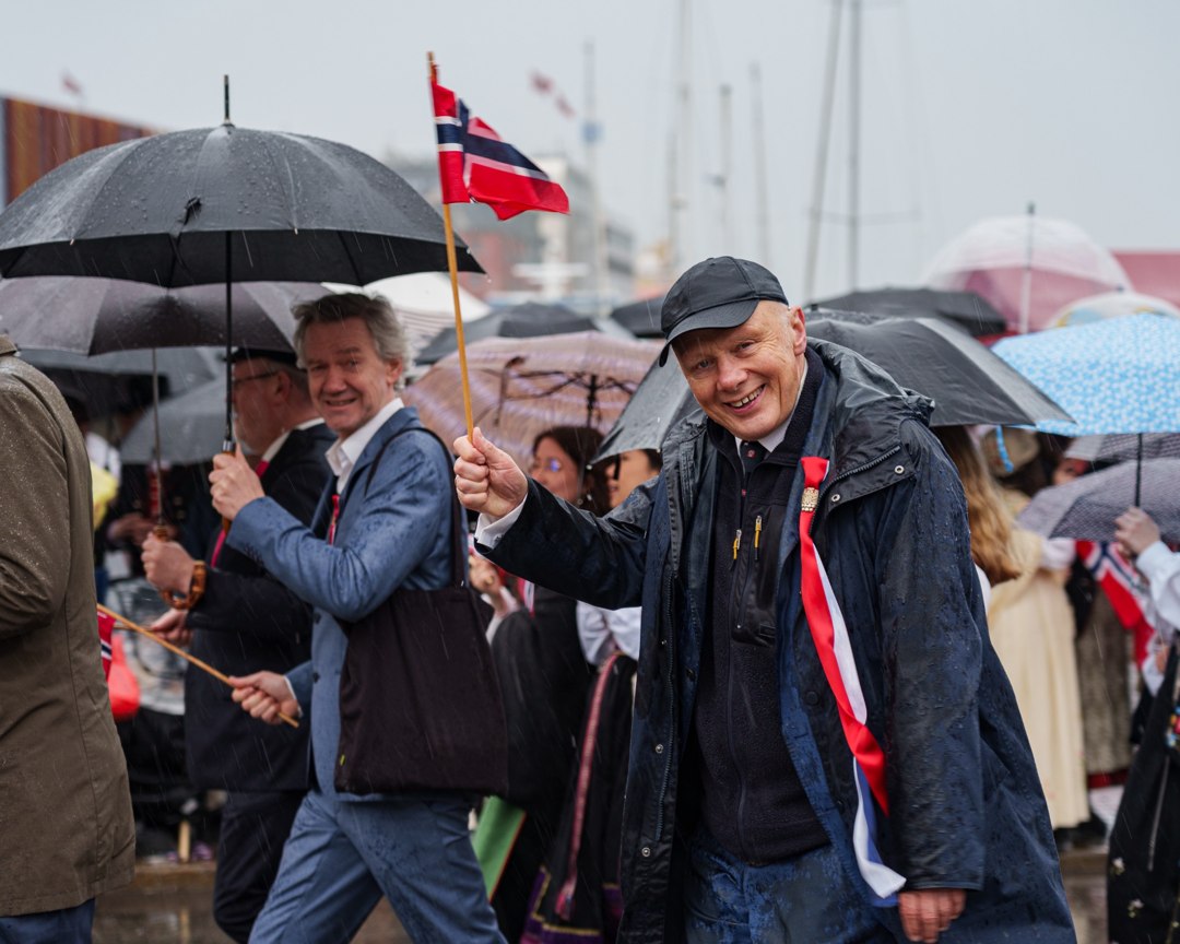 Deltakere med bunad og norske flagg i prosesjonen – A7400396