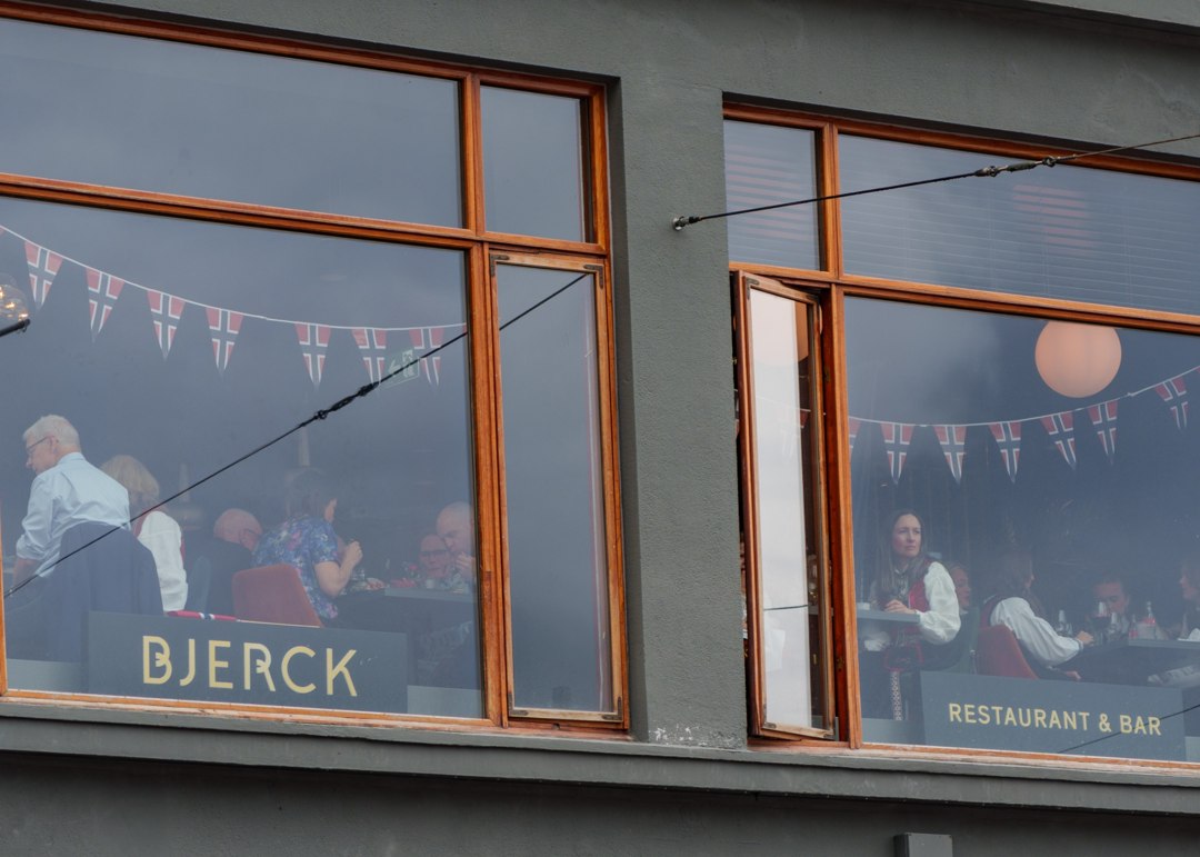 Tilskuere som følger feiringen fra et vindu – A7401067