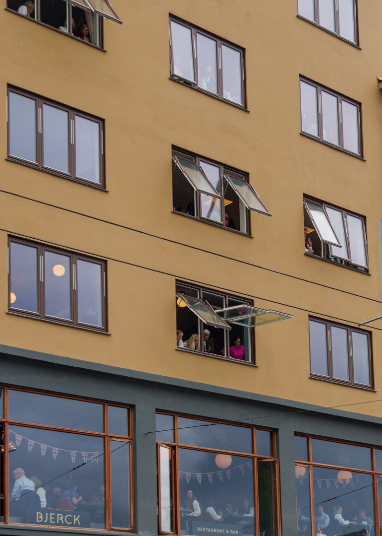 Tilskuere som følger feiringen fra et vindu – A7401068