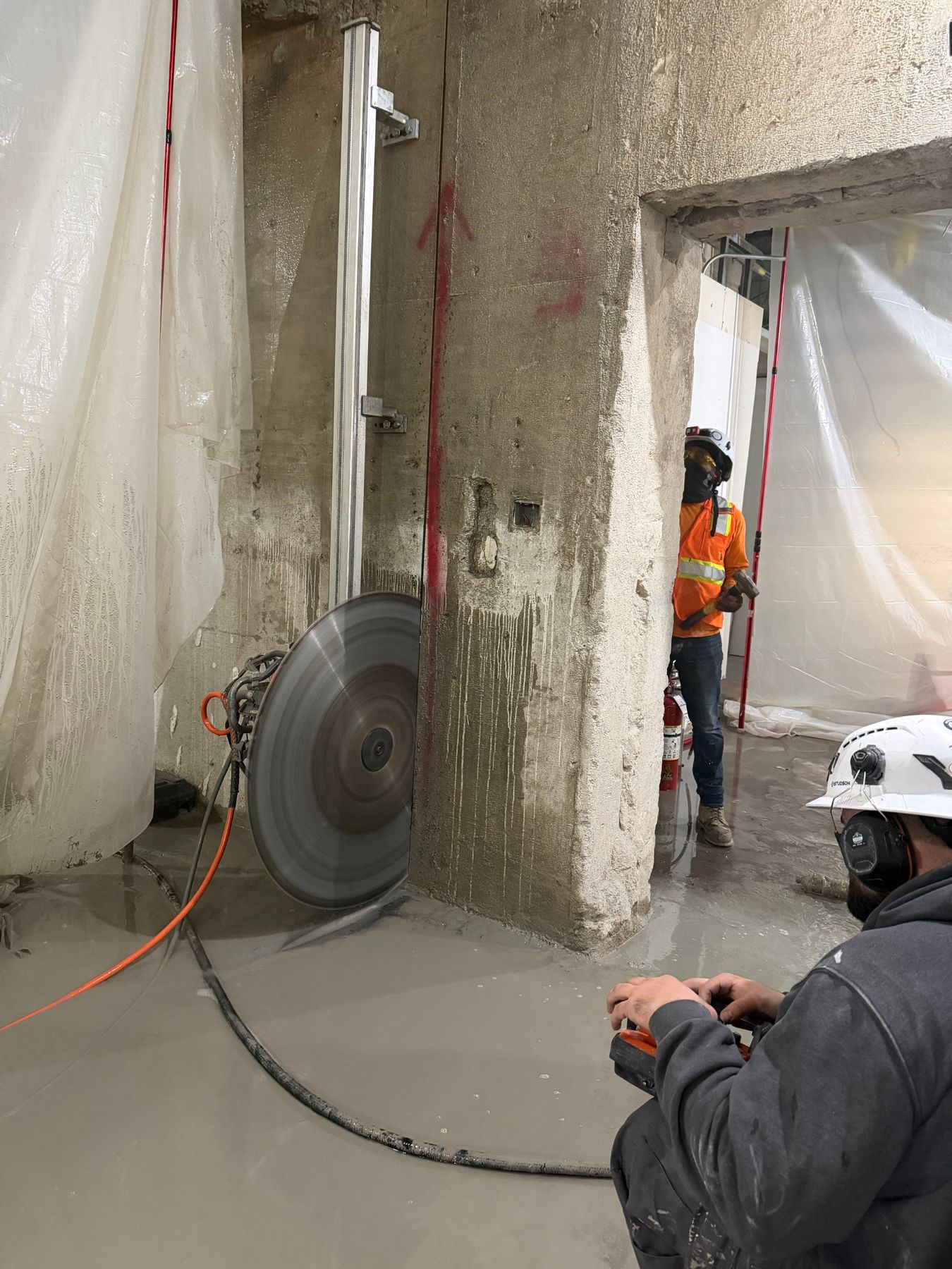 Wall saw crew cutting a concrete wall