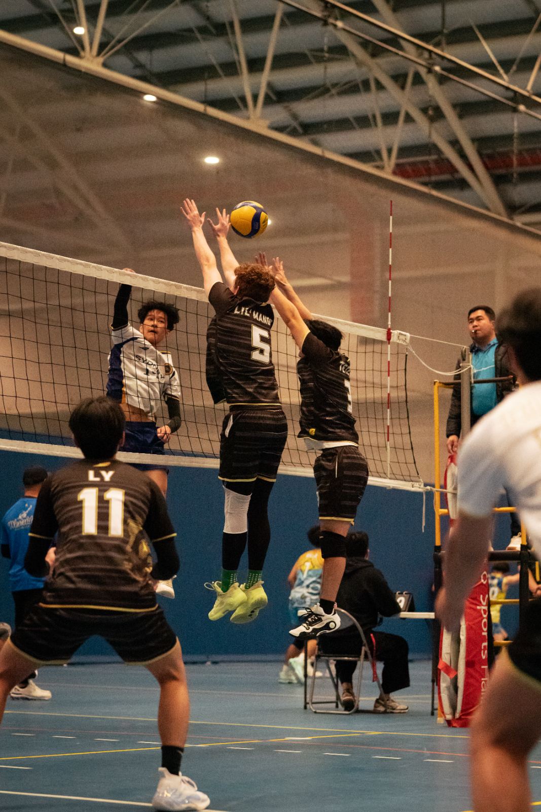 Two players blocking at the net in an intermediate class