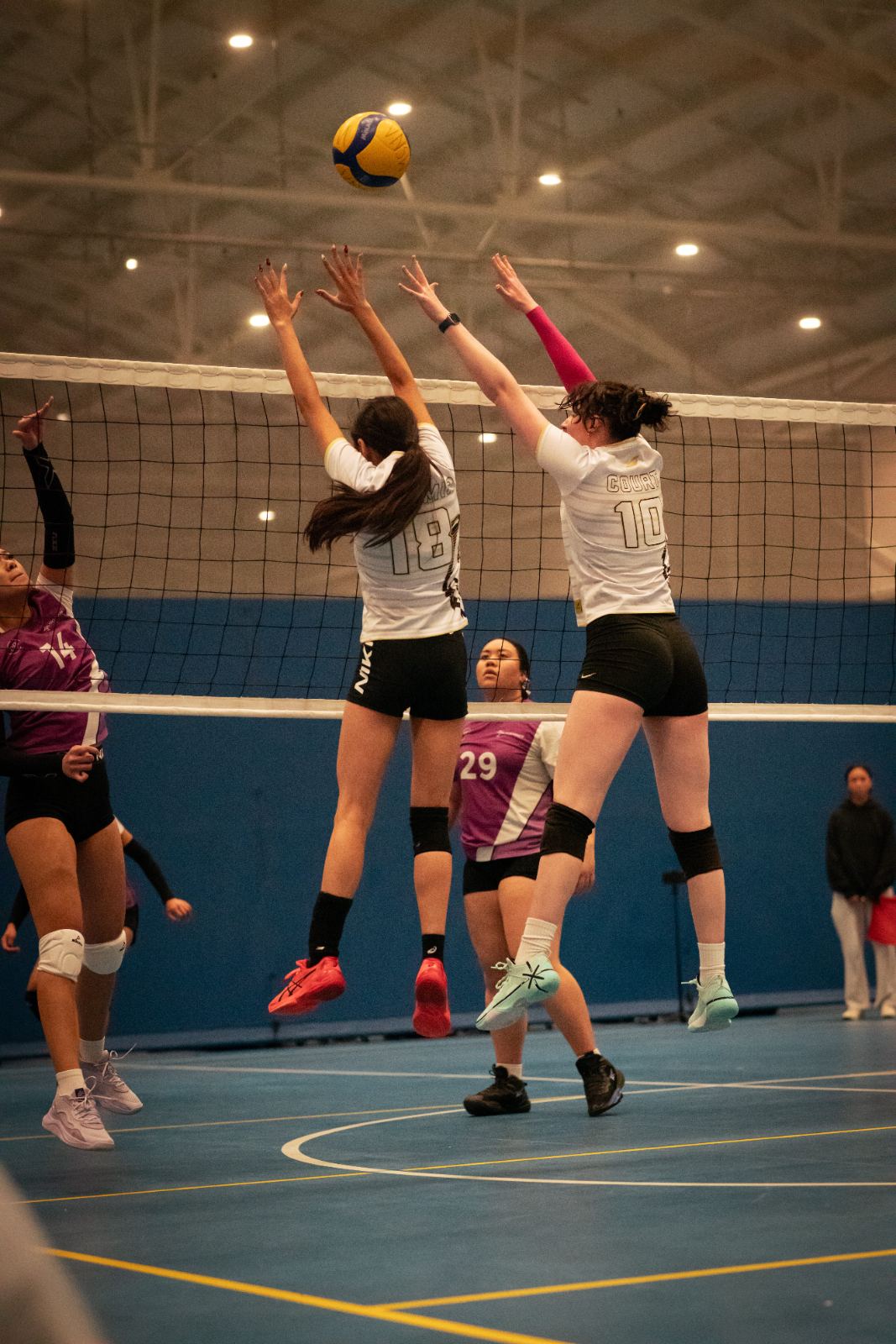 Two teen players blocking at the net