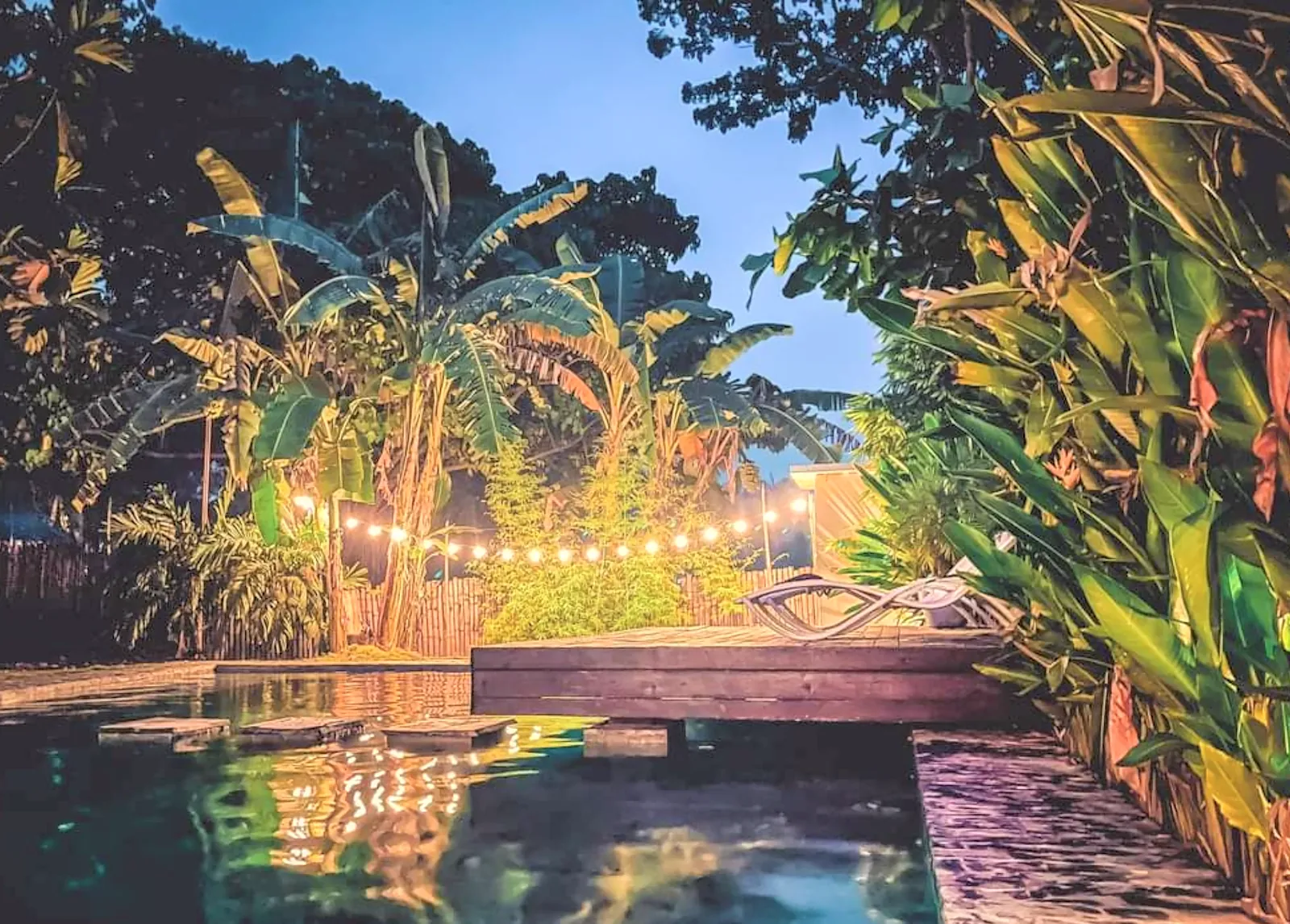Pool and tropical garden lit up at night at Bongo Bongo Divers, Dauin