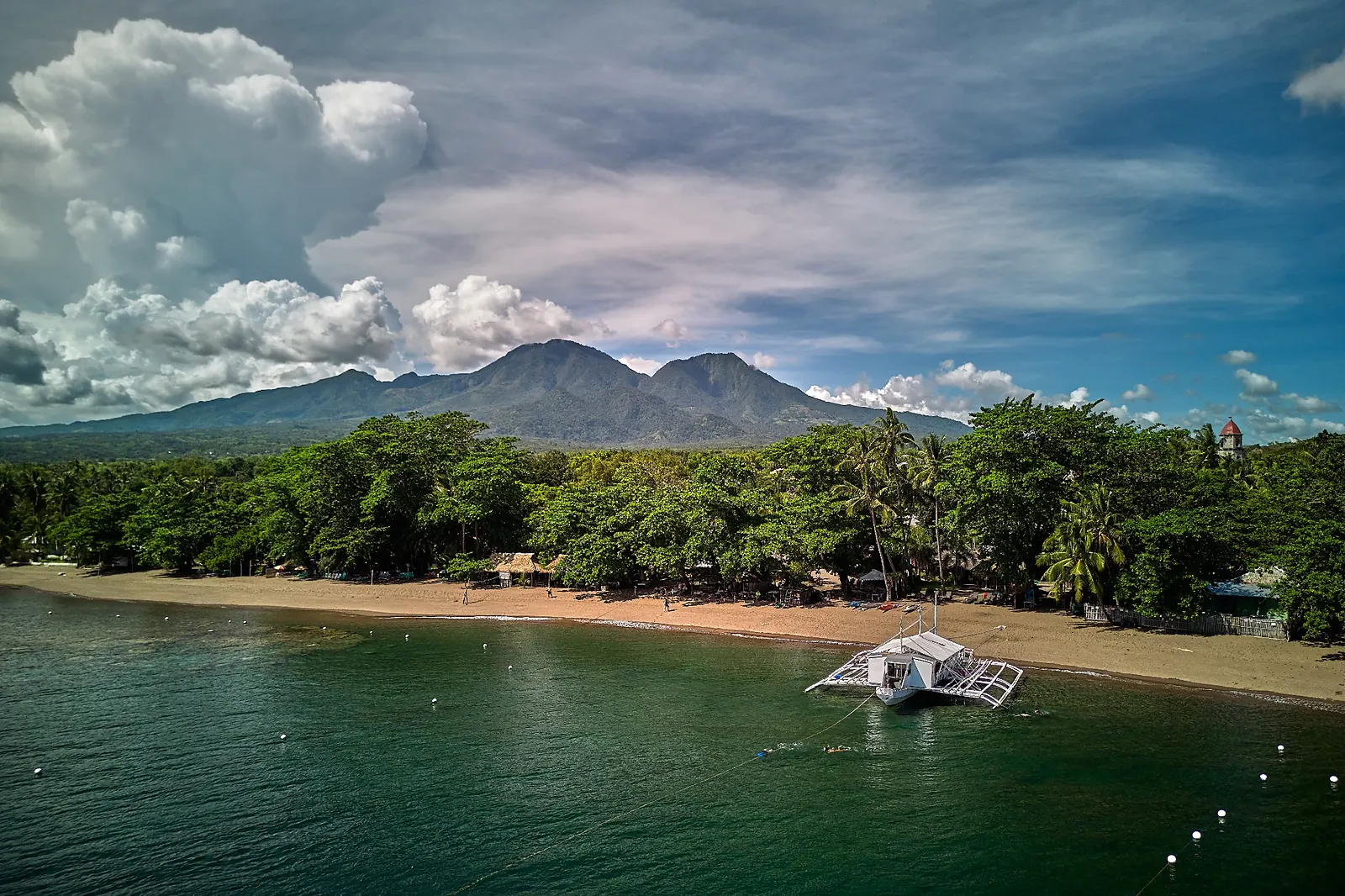 Bongo Bongo dive boat moored off the beach in Dauin, with Apo Island on the horizon