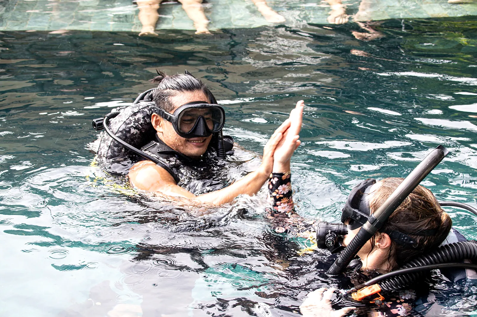 Two scuba students practising together at the surface of a pool