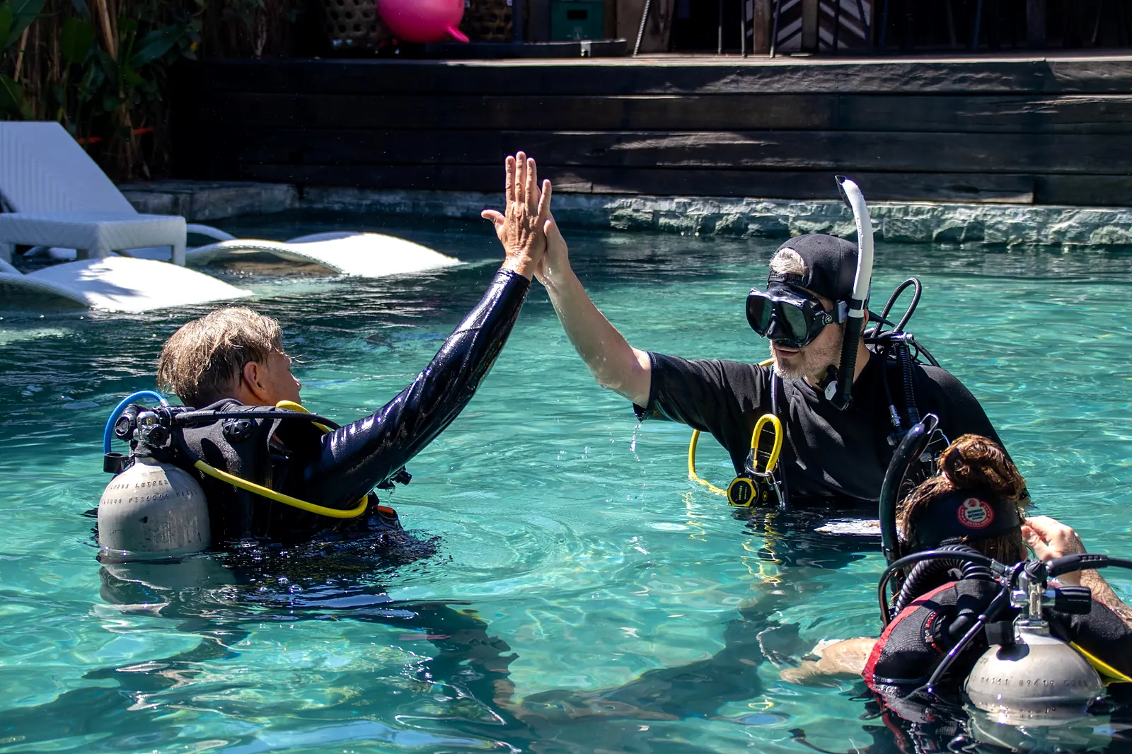 Scuba students exchanging a high five during a pool training session