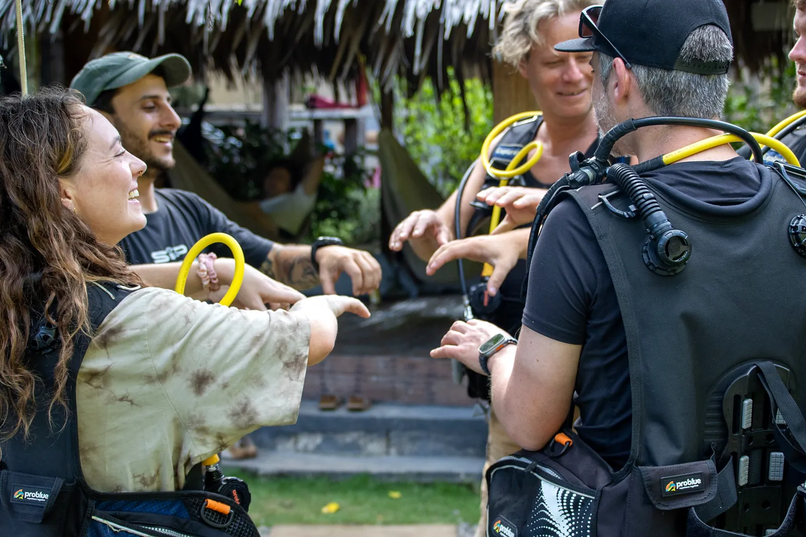 Divers and an instructor preparing their equipment beside the pool