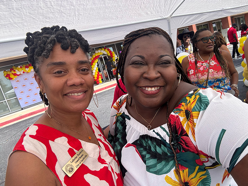Chekema Hector with a guest at the Juici Patties Snellville grand opening