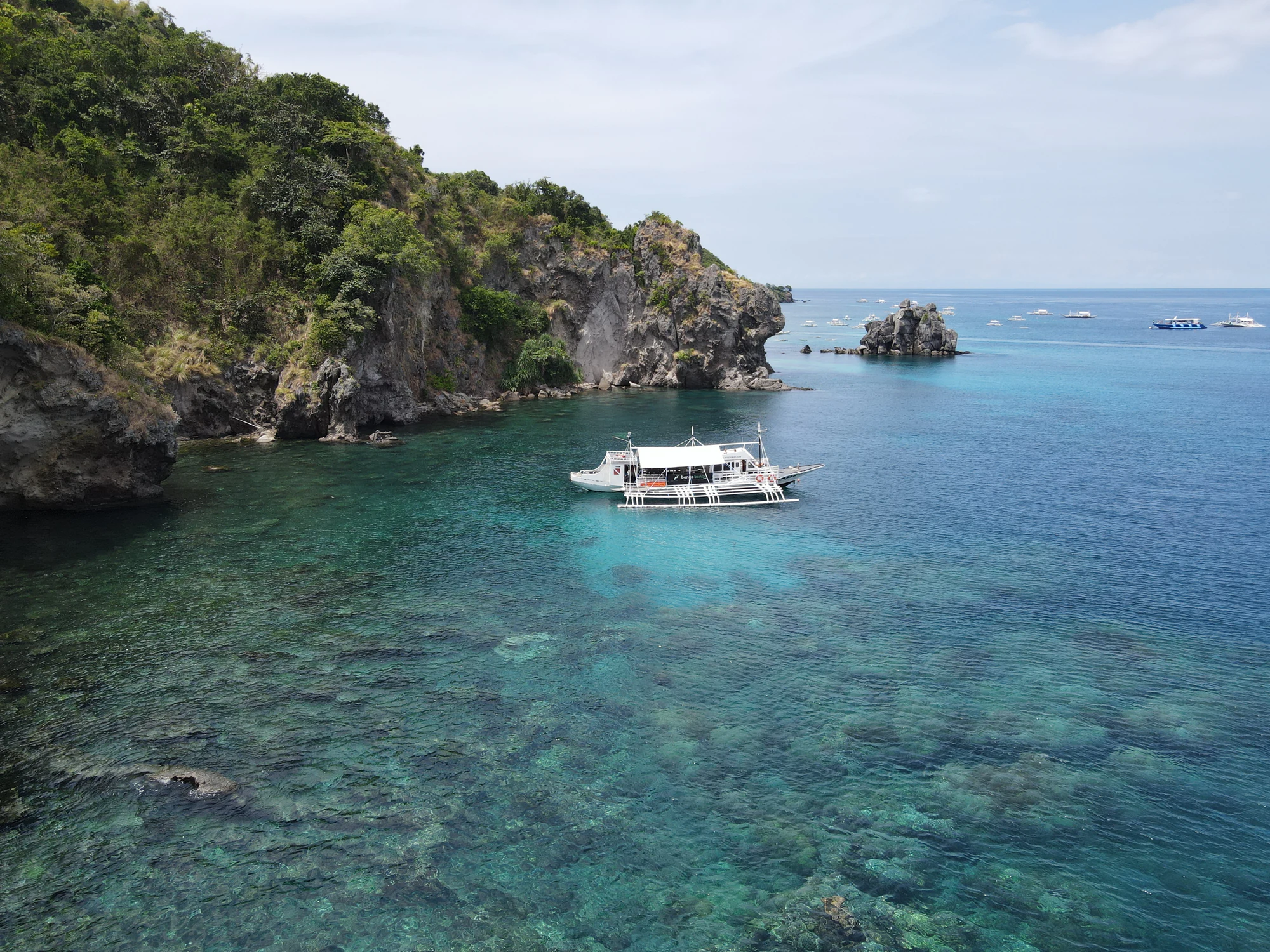 Aerial view of Apo Island with the Bongo Bongo dive boat moored above the reef