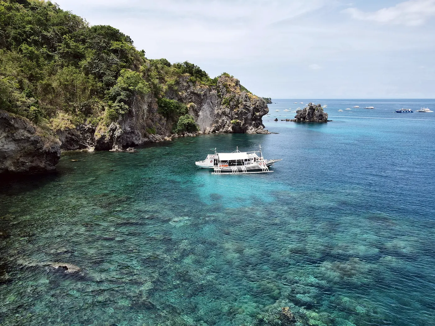 Aerial view of Apo Island with the Bongo Bongo dive boat moored above the reef
