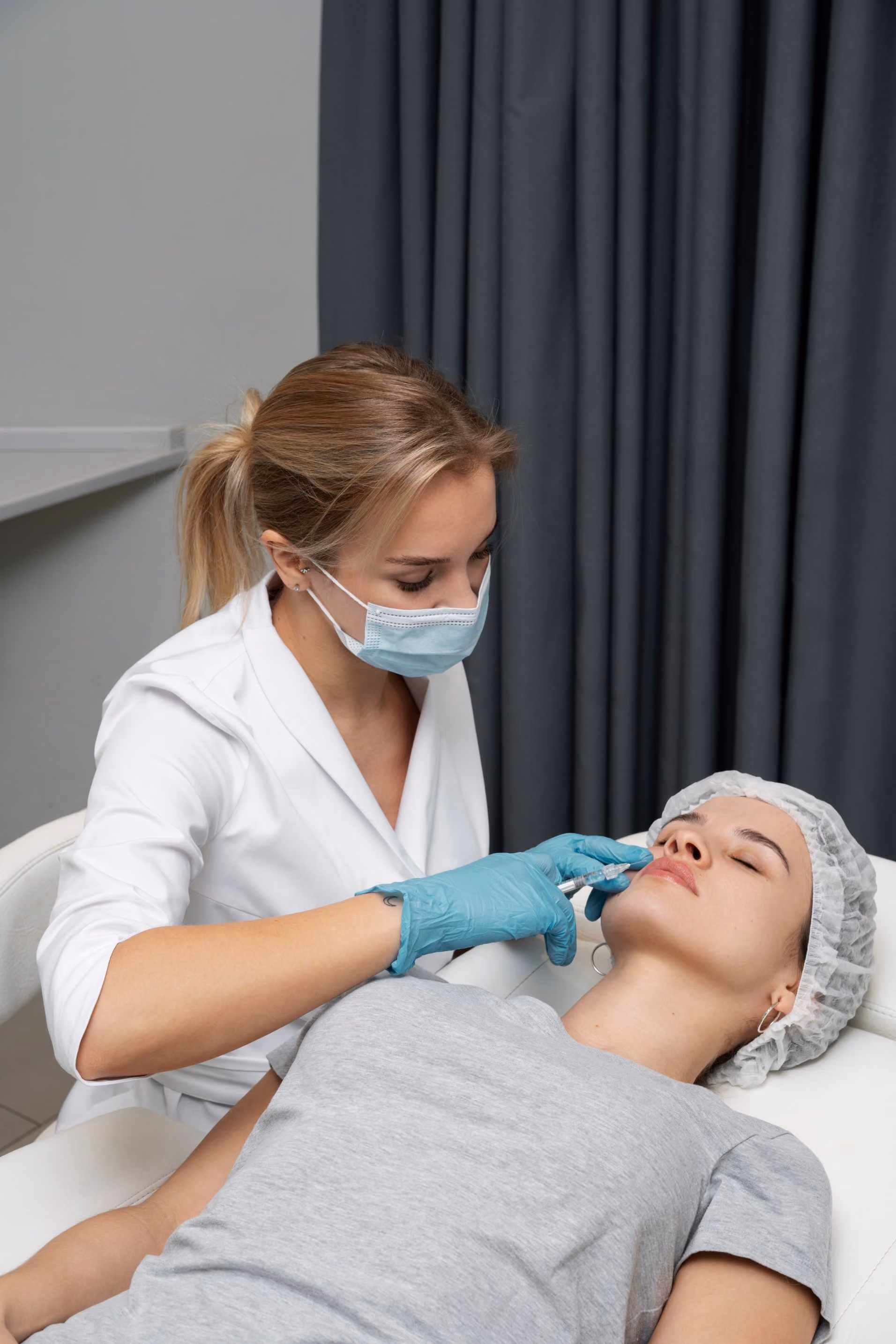 Woman receiving a facial aesthetic treatment from a medical professional