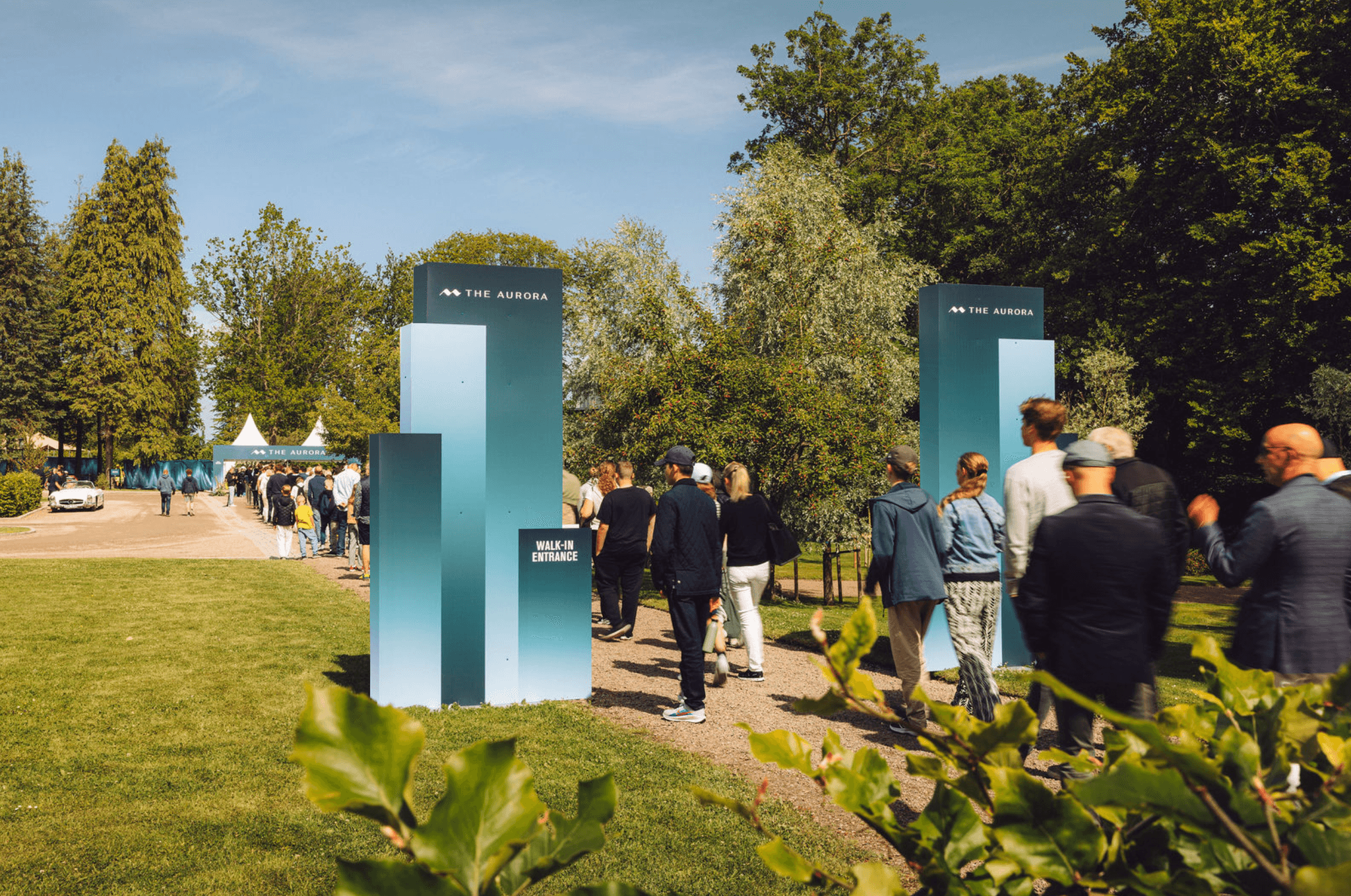 Guests walking past The Aurora wayfinding on the lawn