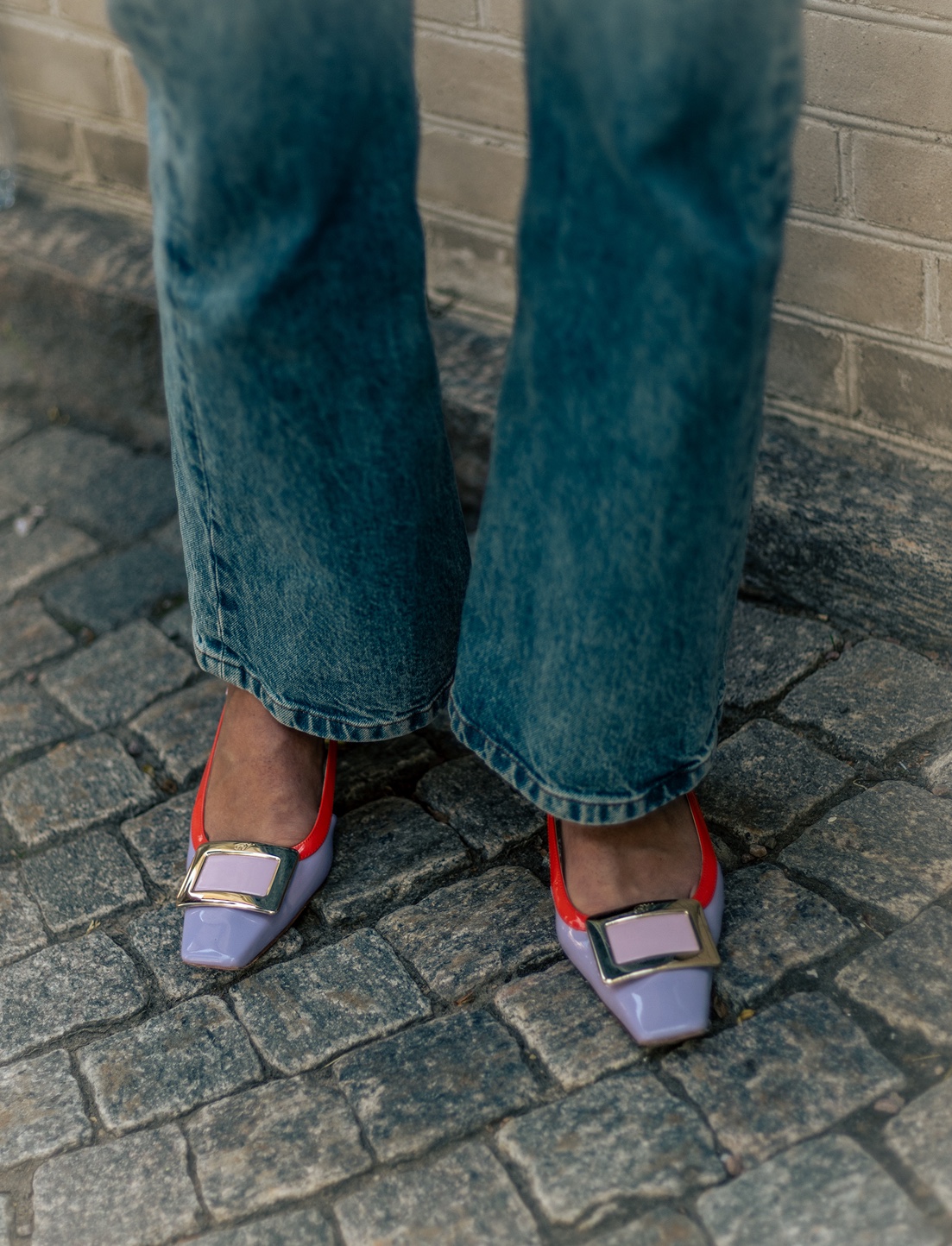 Lilac buckle shoes and denim on cobblestones