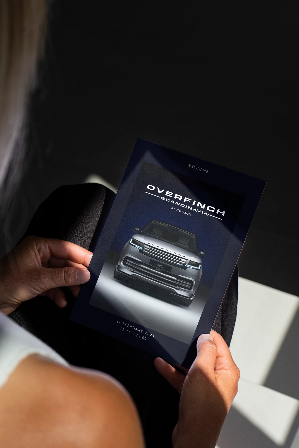 A guest holding the Overfinch Scandinavia welcome programme