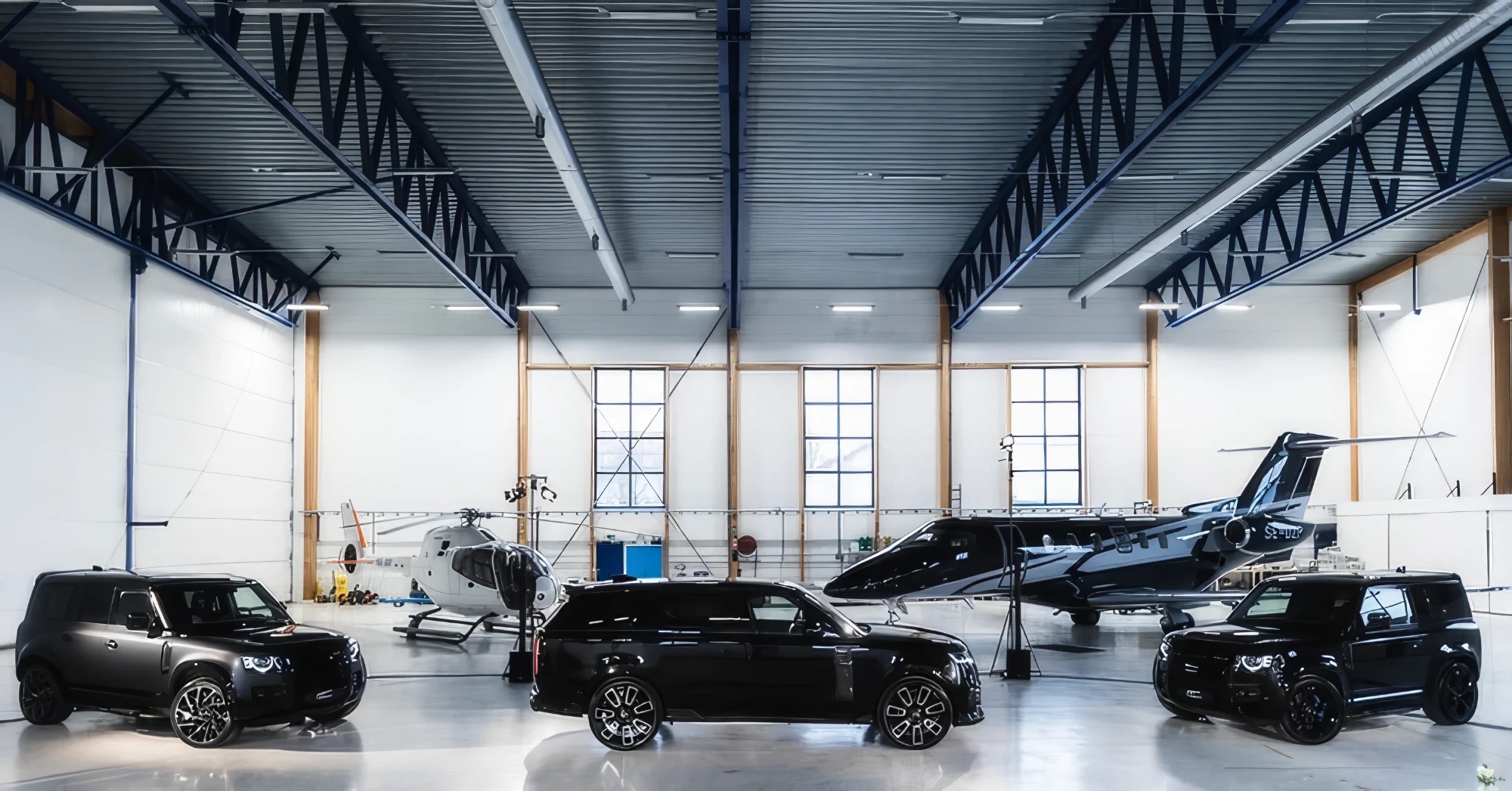Overfinch Range Rover and Defender models with a helicopter and private jet in the Industriflyg hangar