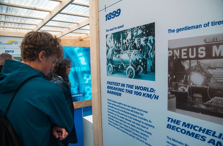 Visitors reading the 1899 history panel: fastest in the world, breaking the 100 km/h barrier