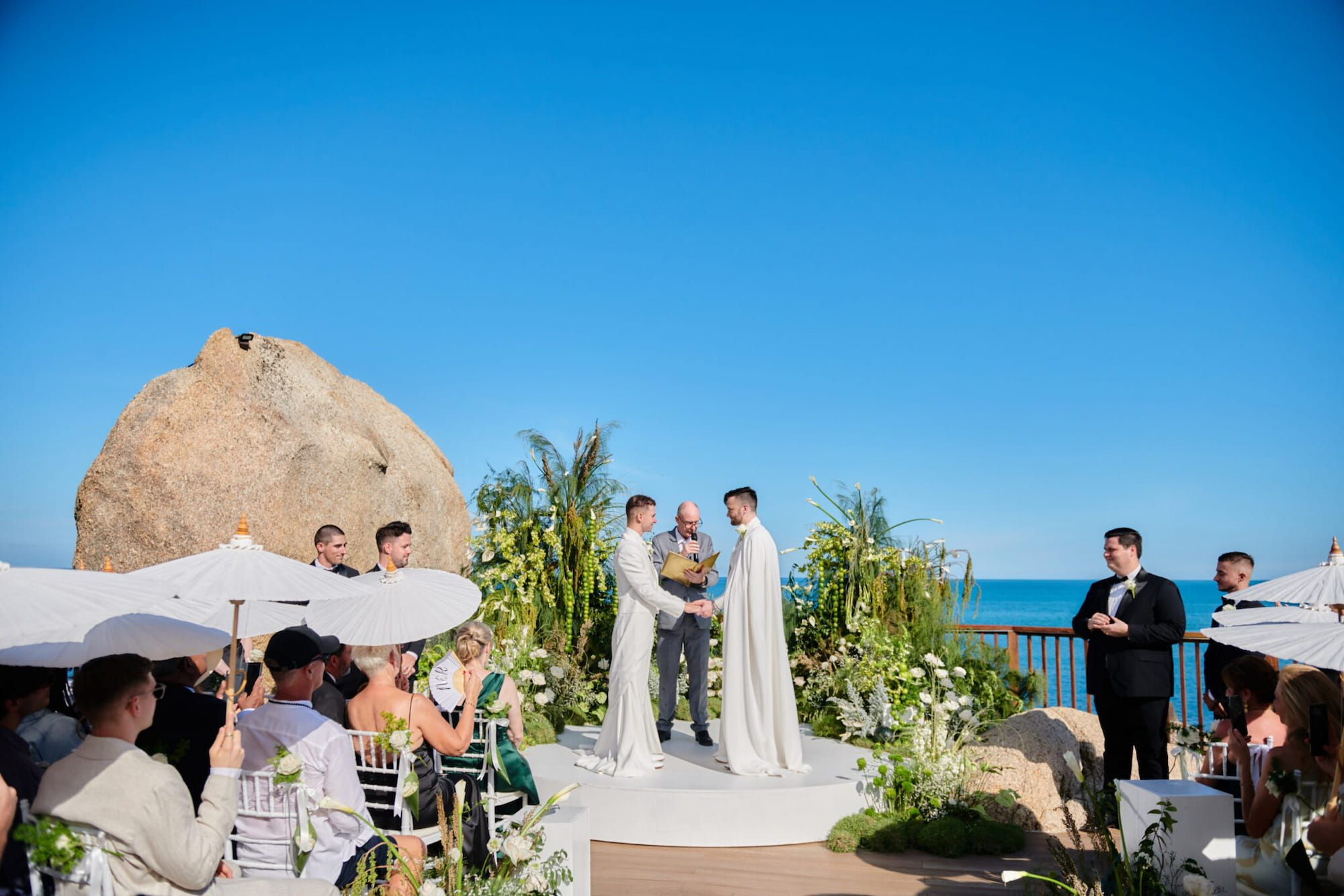Outdoor wedding ceremony on Koh Samui with two grooms exchanging vows