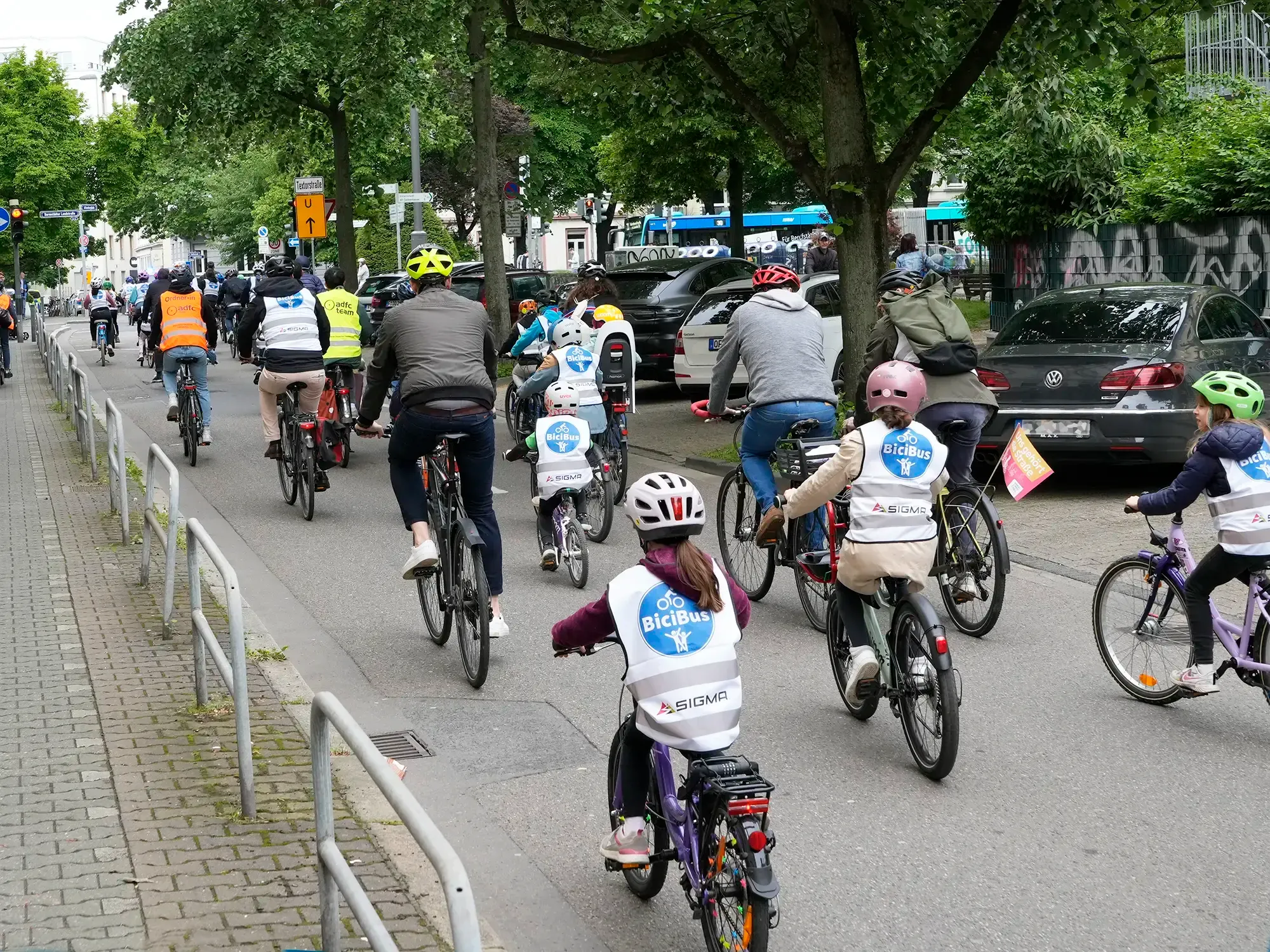 Kinder und Begleitpersonen fahren gemeinsam als BiciBus mit dem Fahrrad zur Schule
