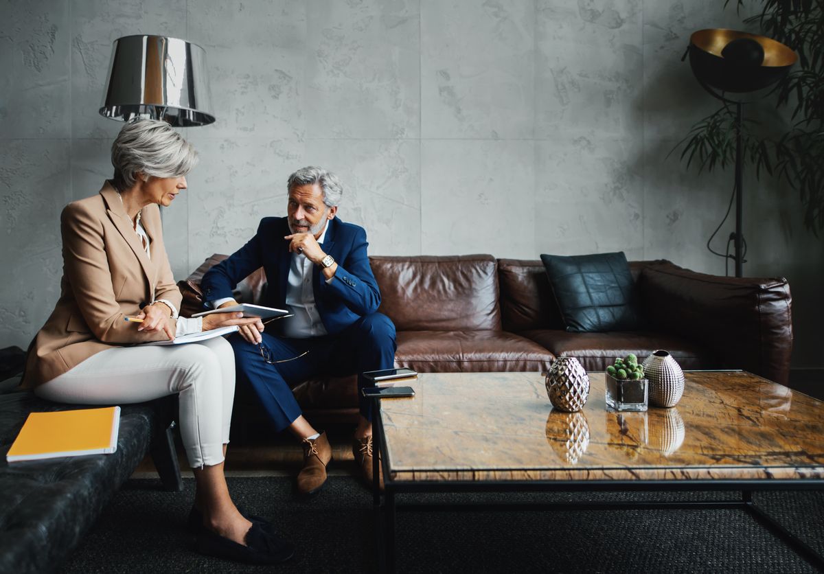 Two advisors in a private meeting on a leather sofa