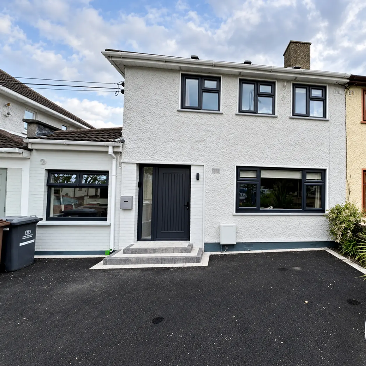 Repainted house exterior with dark UPVC windows and door