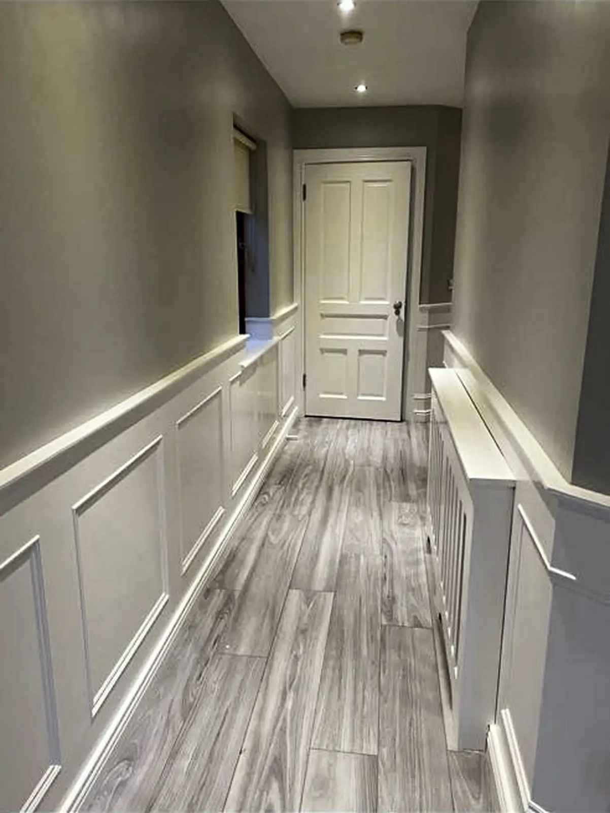 Completed hallway with white painted wall panelling and joinery