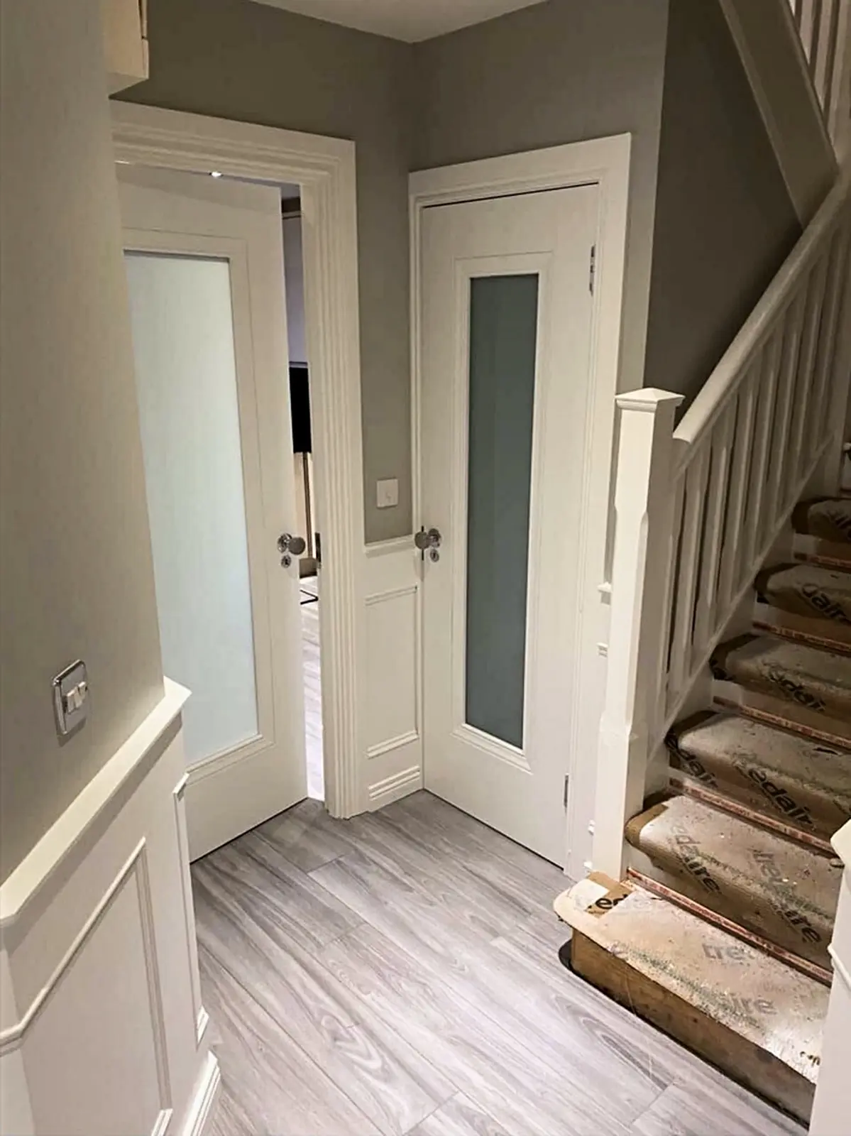 Finished white doors and panelled hallway